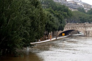 The flooded expressway by the river Seine is pictured near the Pont Neuf bridge (Rear) after its banks became flooded following heavy rainfalls on June 1, 2016 in Paris. Torrential downpours have lashed parts of northern Europe in recent days, leaving four dead in Germany, breaching the banks of the Seine in Paris and flooding rural roads and villages. / AFP PHOTO / FRANCOIS GUILLOT