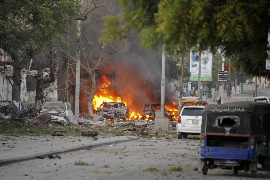 This picture taken on June 1, 2016, shows a car bruning after a terror attack at the Ambassador Hotel, after Somalia's Al-Qaeda-linked Shabaab, launched a deadly attack on a top Mogadishu hotel popular with MPs, setting off a car bomb and fighting security forces inside the complex. Somalia's Al-Qaeda-linked al-Shabaab group was chased out of the capital Mogadishu in 2011 but remains a dangerous threat in both Somalia and neighbouring Kenya, where it carries out frequent attacks. / AFP PHOTO / MOHAMED ABDIWAHAB