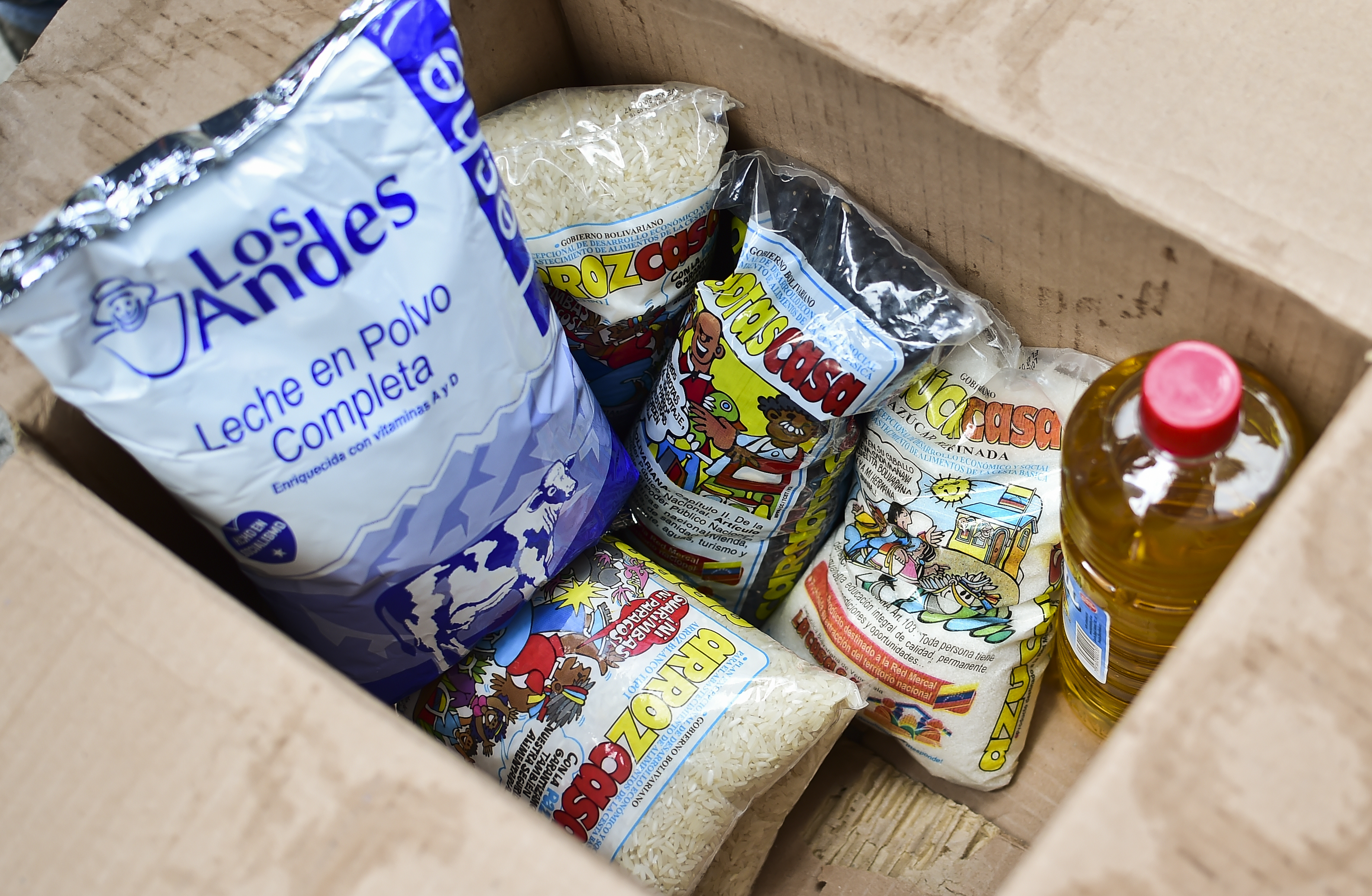 A box with basic foodstuffs is pictured in one of the food distribution centers called CLAP (Local Committees for Supply and Production), which are headed by community leaders, in the poor neighbourhood of 23 de Enero, in Caracas, on June 4, 2016.  Shortages of basic goods have fueled looting, violent crime and vigilante justice. At least 94 looting sprees broke out in the first four months of the year, according to the Venezuelan Observatory for Social Conflict. Venezuela, home to the world's largest oil reserves, has been hit hard by the collapse in global crude prices over the past two years. The economy is forecast to contract eight percent this year, with inflation of 700 percent. / AFP PHOTO / RONALDO SCHEMIDT