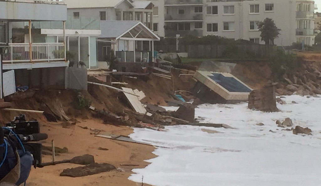An inground pool lies on the beach next to damaged houses after a severe storm at Collaroy on Sydney's northern beaches on June 6, 2016. Wild weather which has smashed into Australia's east coast and whipped up giant waves on Sydney beaches has left at least three people dead and others missing, police as the clean-up began. / AFP PHOTO / BRUCE CLEMENT / ----EDITORS NOTE ----RESTRICTED TO EDITORIAL USE MANDATORY CREDIT " AFP PHOTO / BRUCE CLEMENT" NO MARKETING NO ADVERTISING CAMPAIGNS - DISTRIBUTED AS A SERVICE TO CLIENTS - NO ARCHIVES