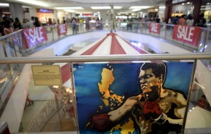In this photo taken on June 4, 2016, shows an artwork by Monica Jane Valerio featuring boxing legend Muhammad Ali, posted inside "Ali-Mall, named after Muhammad Ali as he won a boxing match called "Thrilla in Manila" against Joe Frazier on Araneta Coliseum on October 1, 1975. A bustling shopping mall forms an unlikely monument to the "Thrilla in Manila", but Muhammad Ali's most brutal fight made its biggest impression on the minds of those who witnessed it and still speak of it with awe. / AFP PHOTO / NOEL CELIS