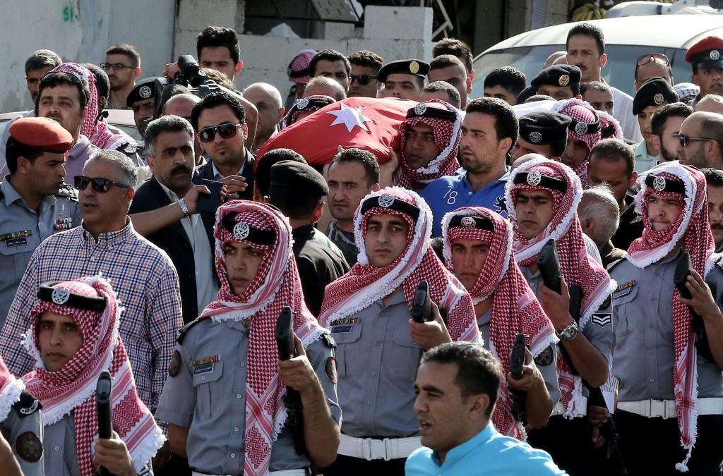 Jordanian mourners carry the body of intelligence corporal Omar al-Hayari, one of the  five Jordanian intelligence agents killed during a gun attack at the Palestinian refugee camp of Baqaa, on June 6, 2016 during his funeral in Salt, a town west of the capital Amman. A gunman apparently acting alone killed the five Jordanian agents in a daylight "terrorist attack" on their office in a Palestinian refugee camp north of the capital. Jordan is a leading member of the US-led coalition fighting the Islamic State group in neighbouring Iraq and Syria, and has been the target of previous jihadist attacks.  / AFP PHOTO / KHALIL MAZRAAWI