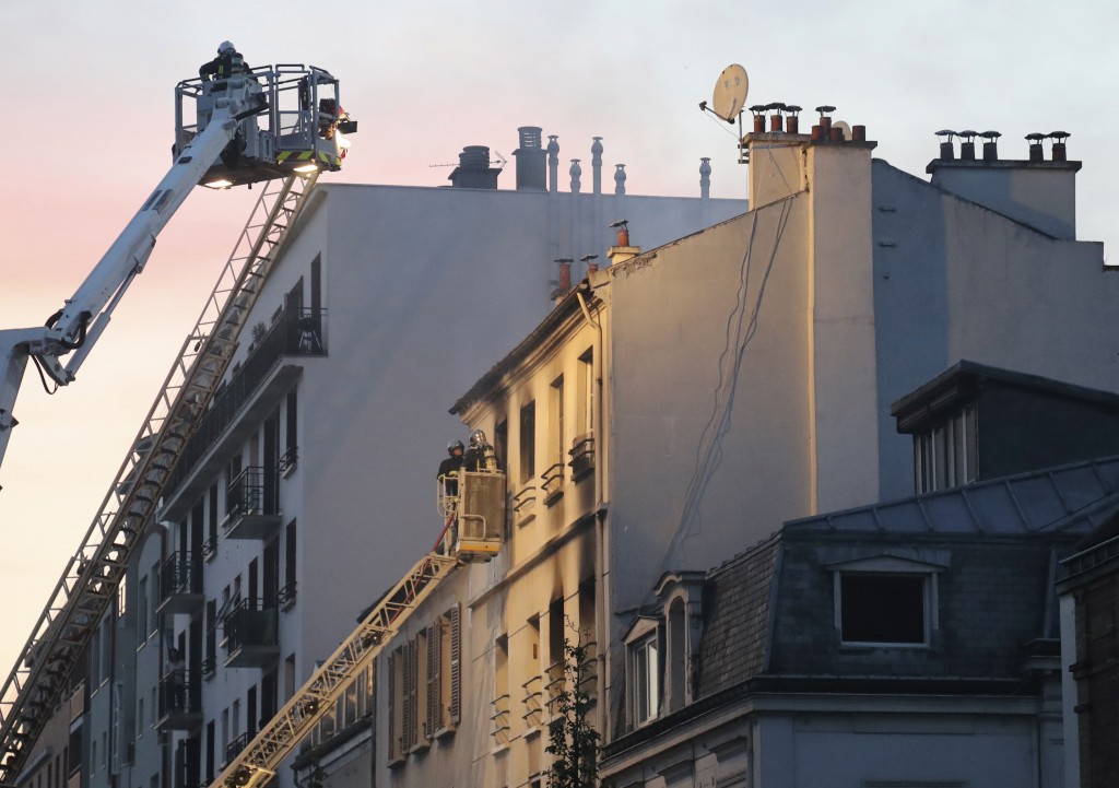 Firemen stand in an aerial bucket to extinguish a fire in a building on June 6, 2016 in Saint-Denis, near Paris. A fire broke out on June 6, 2016 evening in a residential building in central Saint-Denis, causing seven wounded, two seriously, according to concordant sources. / AFP PHOTO / Jacques DEMARTHON