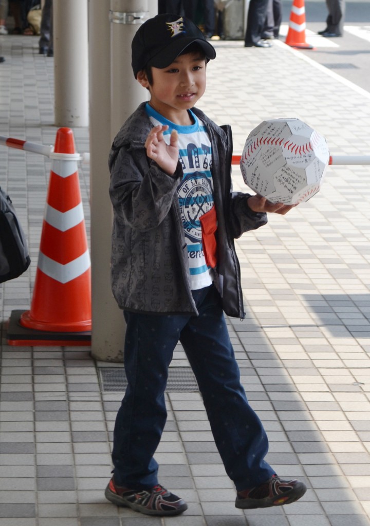 Yamato Tanooka waves to photographers as he leaves the Hakodate Municipal Hospital in Hakodate city, Hokkaido prefecture on June 7, 2016. A seven-year-old boy who survived for nearly a week after being abandoned by his parents in a forest left hospital on June 7, capping a 10-day drama that captivated Japan and sparked a national conversation about child discipline. / AFP PHOTO / JIJI PRESS / JIJI PRESS / Japan OUT