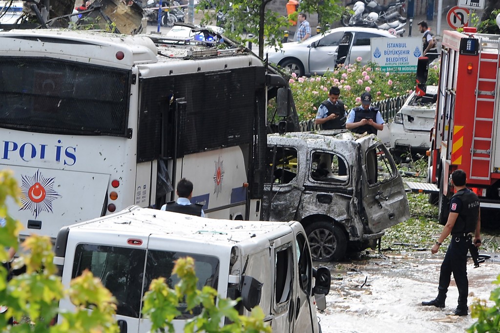 ALTERNATIVE CROP Police officers and rescuers inspect the site of a bomb attack that targeted a police bus in the Vezneciler district of Istanbul on June 7, 2016. A bomb attack targeted Turkish police in a central Istanbul district on June 7, 2016, leaving several people wounded, the state-run TRT television reported. / AFP PHOTO / DOGAN NEWS AGENCY / STRINGER / Turkey OUT