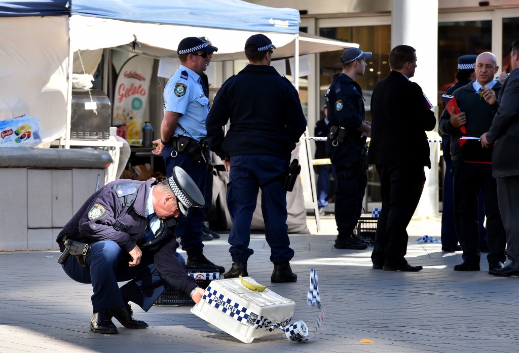 Officers investigate the scene of a police shooting at the shopping arcade in the Hornsby area of Sydney on June 9, 2016. Three elderly bystanders were wounded on June 9 when Australian police opened fire on a man wielding a large carving knife in a busy Sydney shopping centre, authorities said. / AFP PHOTO / SAEED KHAN
