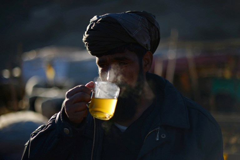 (FILES) This file photo taken on February 12, 2014 shows an Afghan trader drinking tea in Kabul. Drinking very hot beverages "probably" causes cancer of the oesophagus, the UN's cancer agency said on June 14, 2016, while lifting suspicion from coffee and the herbal drink mate if consumed at "normal serving temperatures". "These results suggest that drinking very hot beverages is one probable cause of oesophageal cancer and that it is the temperature, rather than the drinks themselves, that appears to be responsible," said Christopher Wild, director of the International Agency for Research on Cancer (IARC). / AFP PHOTO / WAKIL KOHSAR