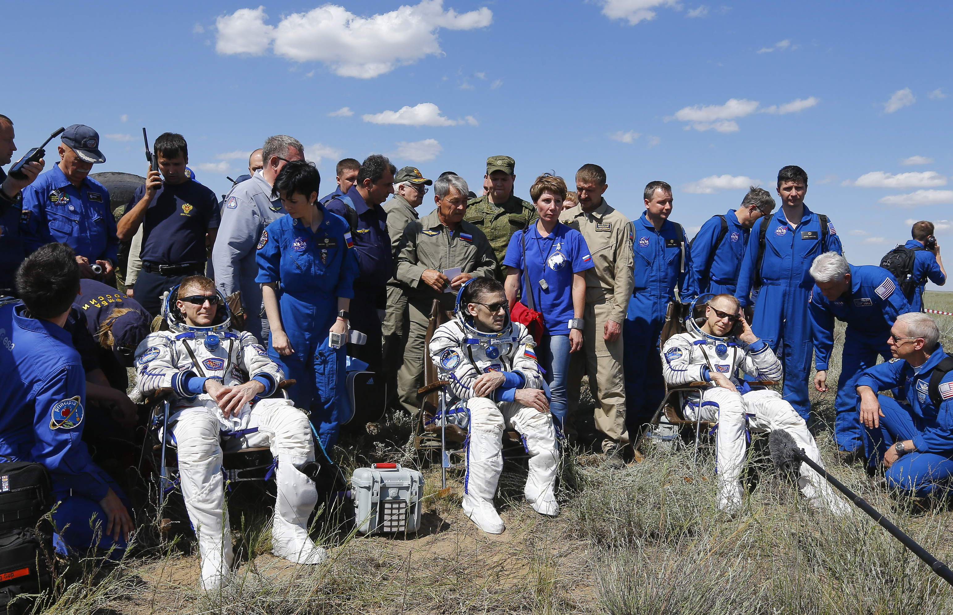 From L: The International Space Station (ISS) crew members Tim Peake of Britain, Yuri Malenchenko of Russia and Tim Kopra of the U.S. rest in chairs shortly after landing near the town of Zhezkazgan, Kazakhstan, on June 18, 2016. / AFP PHOTO / POOL / SHAMIL ZHUMATOV