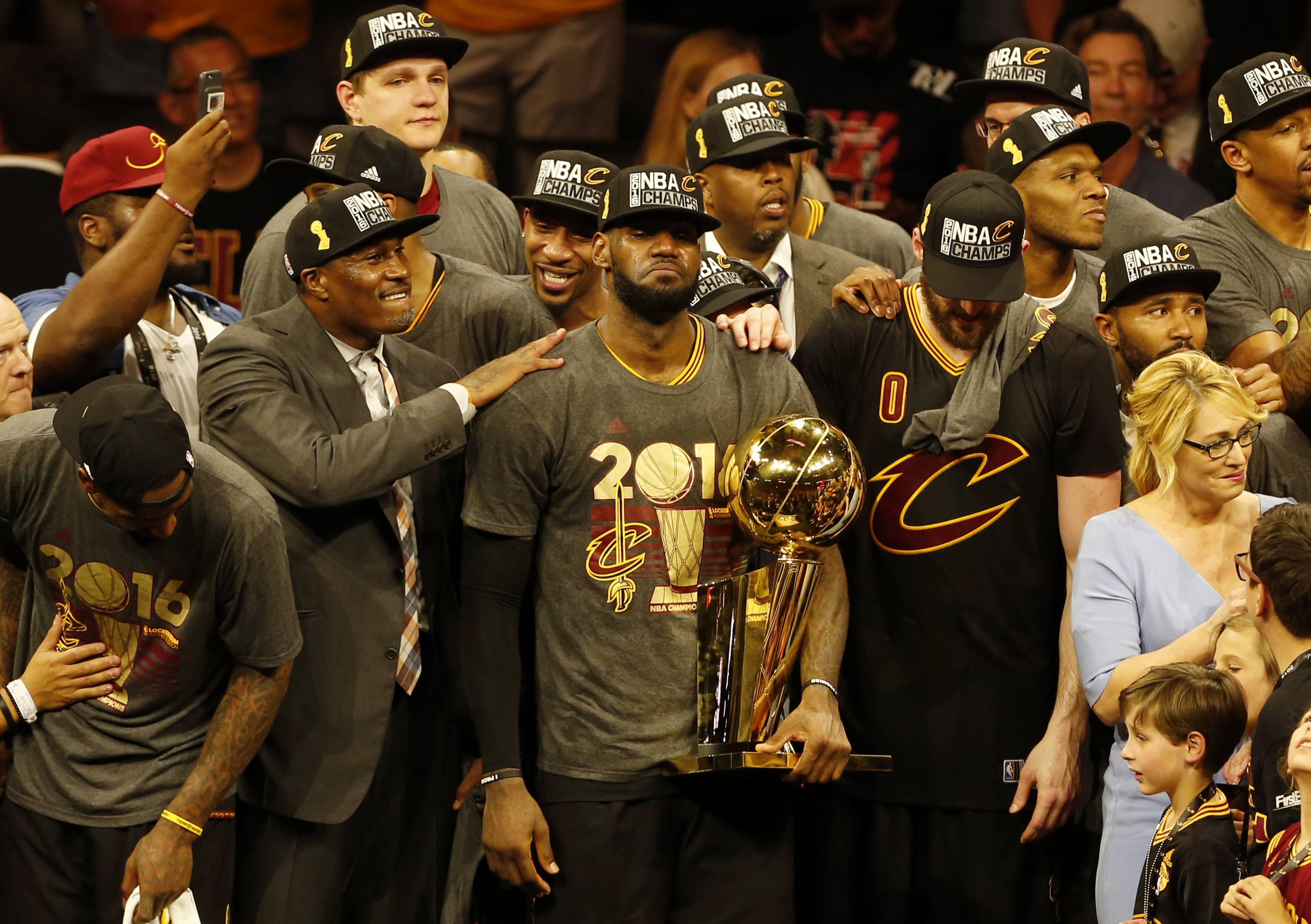 Cleveland Cavaliers forward LeBron James reacts while holding the Larry O'Brien trophy after defeating the Gold State Warriors to win the NBA Finals on June 19, 2016 in Oakland, California. Powered by an amazing effort from LeBron James, the Cleveland Cavaliers completed the greatest comeback in NBA Finals history, dethroning defending champion Golden State 93-89 to capture their first NBA title. The Cavaliers won the best-of-seven series 4-3 to claim the first league crown in their 46-season history and deliver the first major sports champion to Cleveland since the 1964 NFL Browns, ending the longest such title drought for any American city.  / AFP PHOTO / Beck Diefenbach