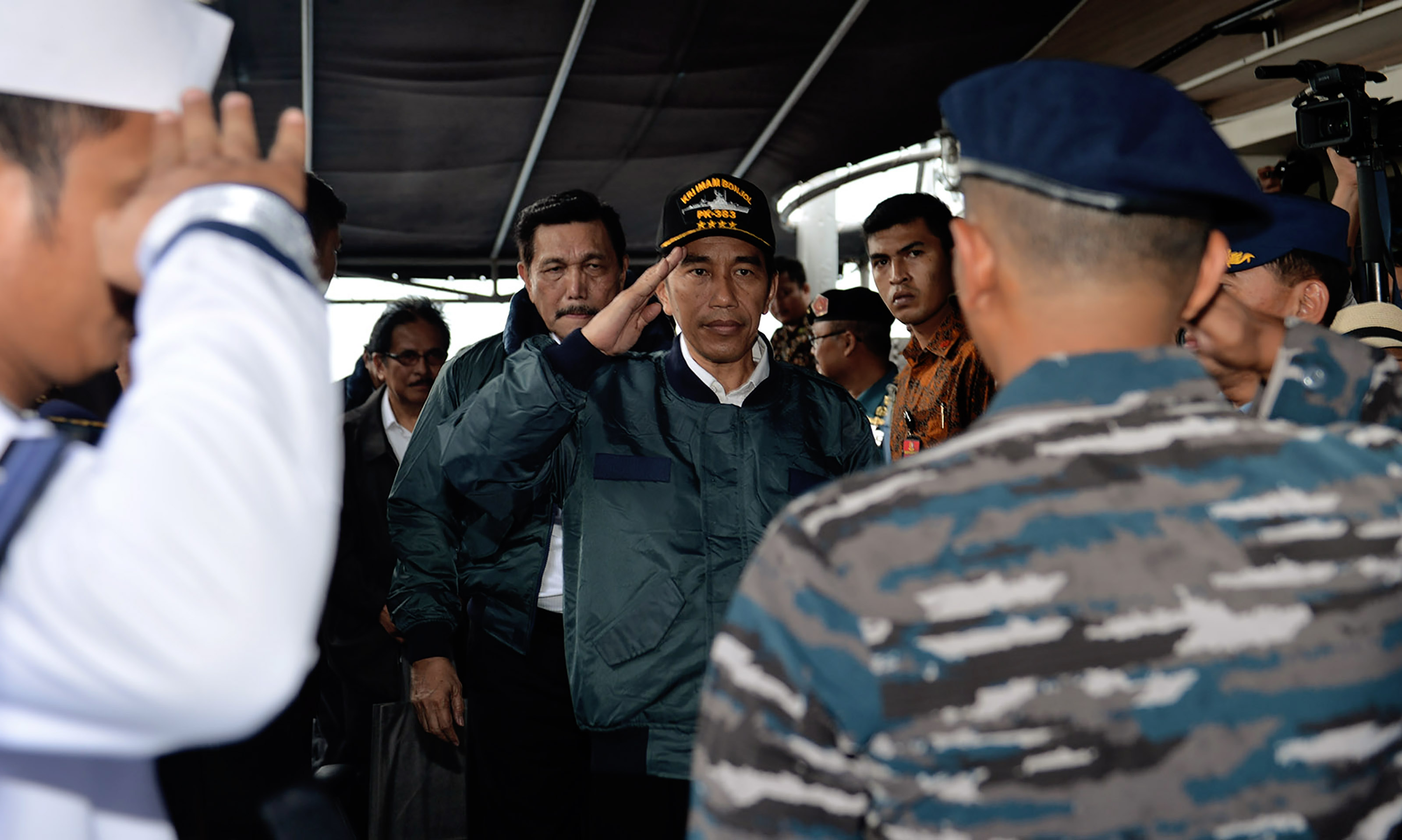 This handout photo taken and released by the Presidential Palace on June 23, 2016 shows Indonesian President Joko Widodo (C) saluting onboard the Imam Bonjol warship in Indonesia's Natuna Islands in the South China Sea. President Joko Widodo visited remote Indonesian islands on a warship on June 23 in an apparent show of force after clashes with Chinese vessels and as fears grow Beijing is seeking to stake a claim in the area. / AFP PHOTO / PRESIDENTIAL PALACE / STR / --- EDITORS NOTE --- RESTRICTED TO EDITORIAL USE - MANDATORY CREDIT "AFP PHOTO /  PRESIDENTIAL PALACE" - NO MARKETING NO ADVERTISING CAMPAIGNS - DISTRIBUTED AS A SERVICE TO CLIENTS - NO ARCHIVES