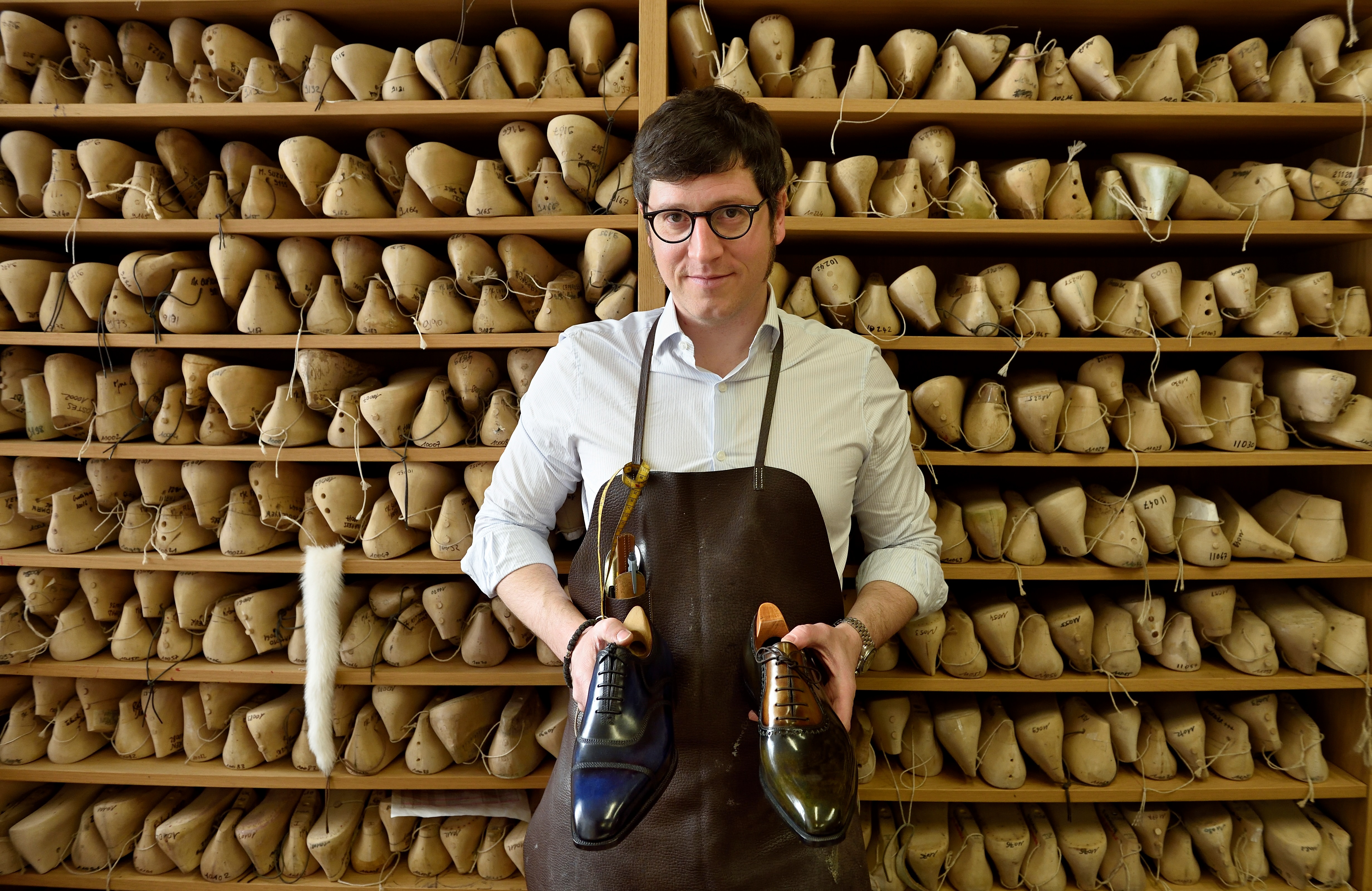 (FILES) This file photo taken on May 3, 2016 shows Berluti's master luxury shoemaker Jean-Michel Casalonga posing in the Berluti's workshop in Paris. Far from the excitement of the Paris Fashion Week, the luxury shoemaker Berluti manufactures its custom-made shoes for men in a discrete workshop off the Champs-Elysees, producing numbered and a limited amount of hundreds of pairs a year for clients all over the world . / AFP PHOTO / Eric Feferberg