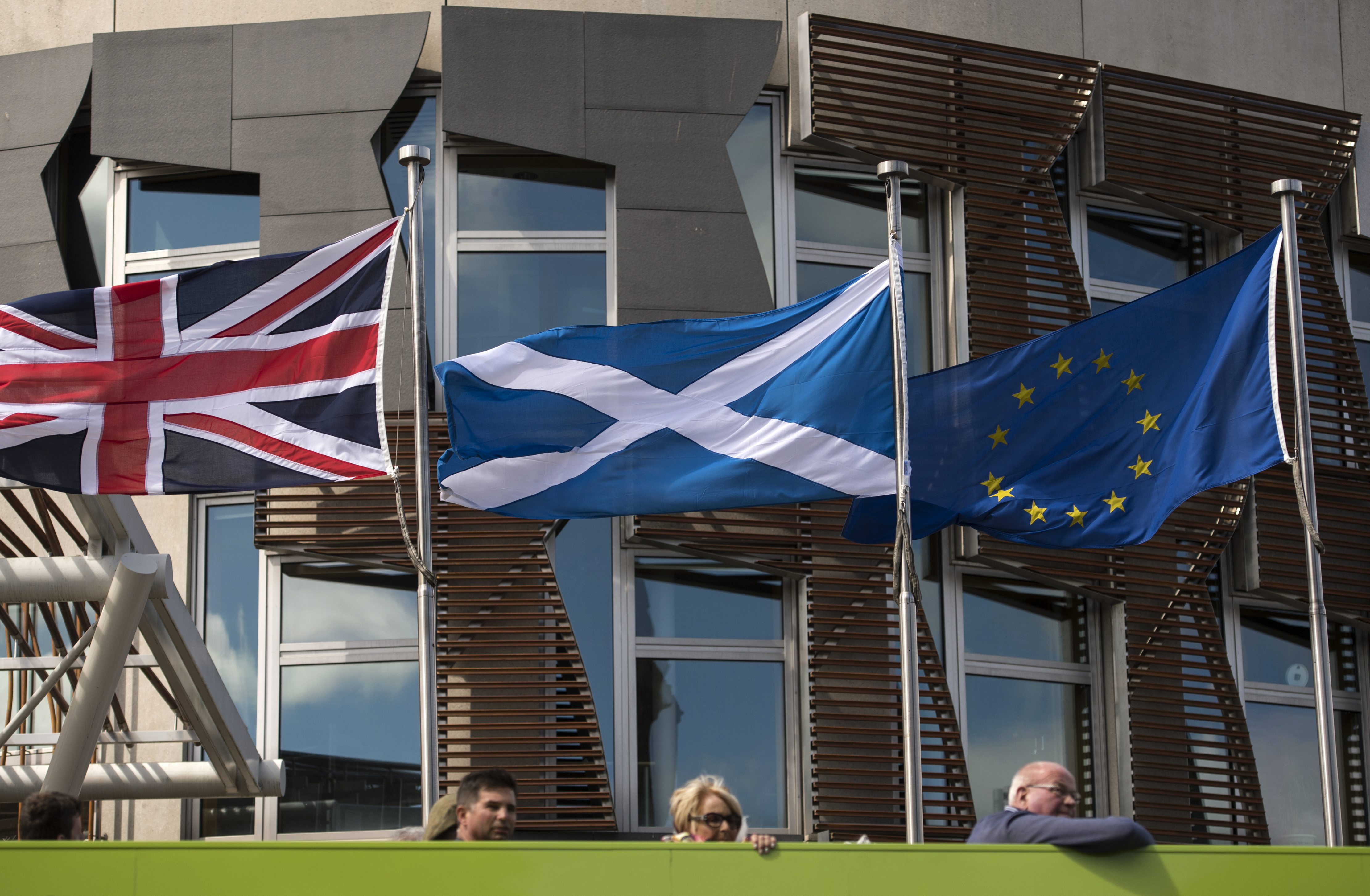 A Scottish Saltire (C) flies between a Union flag (L) and a European Union (EU) flag in front of the Scottish Parliament building in Edinburgh, Scotland on June 27, 2016. British leaders battled to calm markets and the country Monday after its shock vote to leave the EU, while insisting London would be not rushed into a quick divorce. Britain's historic decision to be the first country to leave the 28-nation bloc has fuelled fears of a break-up of the United Kingdom with Scotland eyeing a new independence poll, and created turmoil in the opposition Labour party where leader Jeremy Corbyn is battling an all-out revolt. / AFP PHOTO / OLI SCARFF