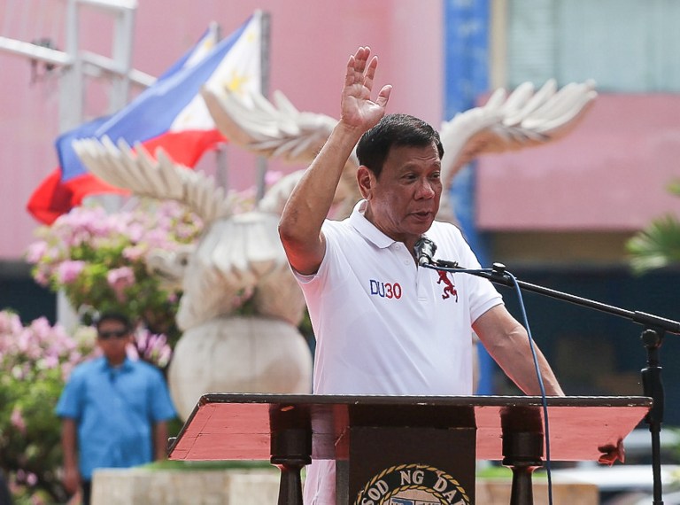 This photo taken on June 27, 2016 shows Philippines president-elect Rodrigo Duterte gesturing as he speaks before city hall employees in Davao City, in southern island of Mindanao, day before taking oath of office. Duterte takes office this week looking to end the domination of "Imperial Manila" with a radical shift to federalism that he says is vital to fighting poverty and ending a deadly Muslim separatist insurgency. / AFP PHOTO / MANMAN DEJETO / TO GO WITH AFP STORY: Philippines-politics-Duterte-federalism, FOCUS by Mynardo Macaraig