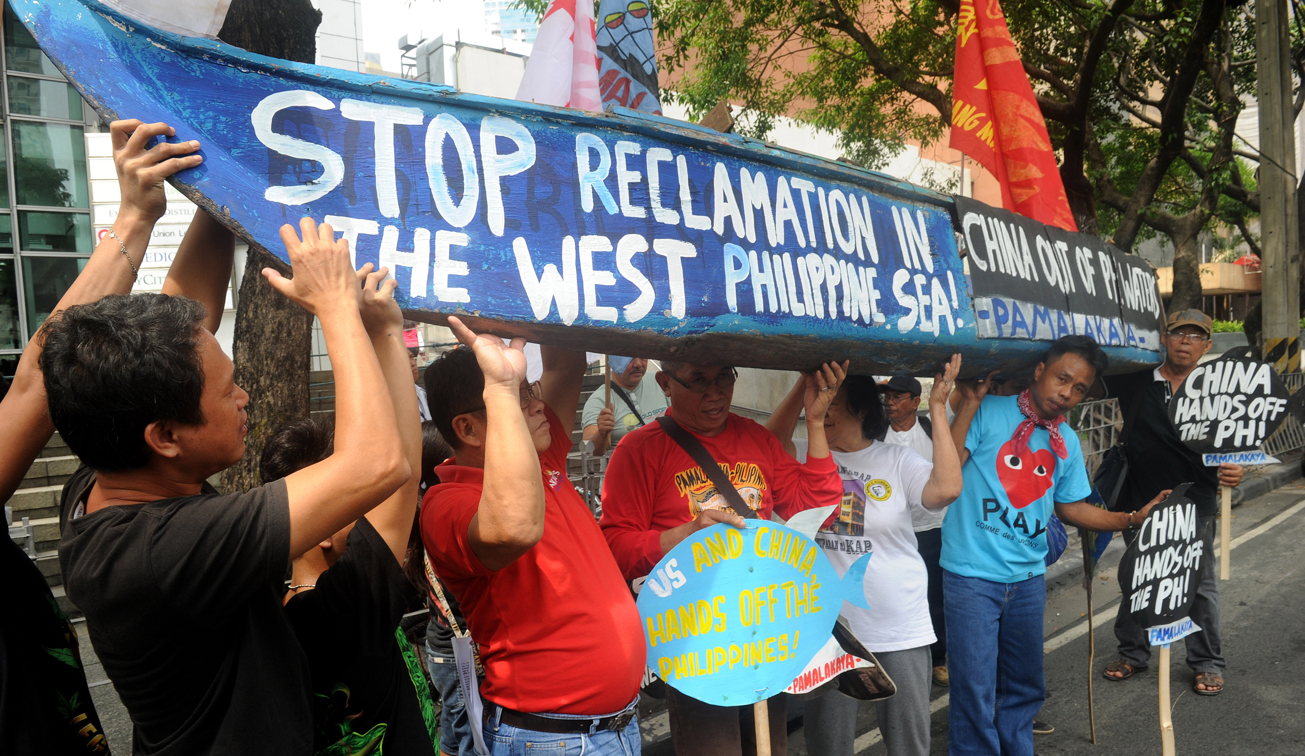 Activists hold a rally in front of the Chinese consulate in Manila's financial district on July 3, 2015 to protest China's reclamation works in the South China Sea, which the protesters have displaced Filipino fishermen. The Philippines has halted the repair of its airstrip in the disputed Spratly islands due to its pending suit at The Hague challenging China's claim over the waters, a presidential spokesman said on June 28.  Hearings at The Hague -- looking at whether Manila's complaint has legal merit as well as whether the court has jurisdiction over the case -- are set to begin next week.     AFP PHOTO / Jay DIRECTO / AFP PHOTO / JAY DIRECTO