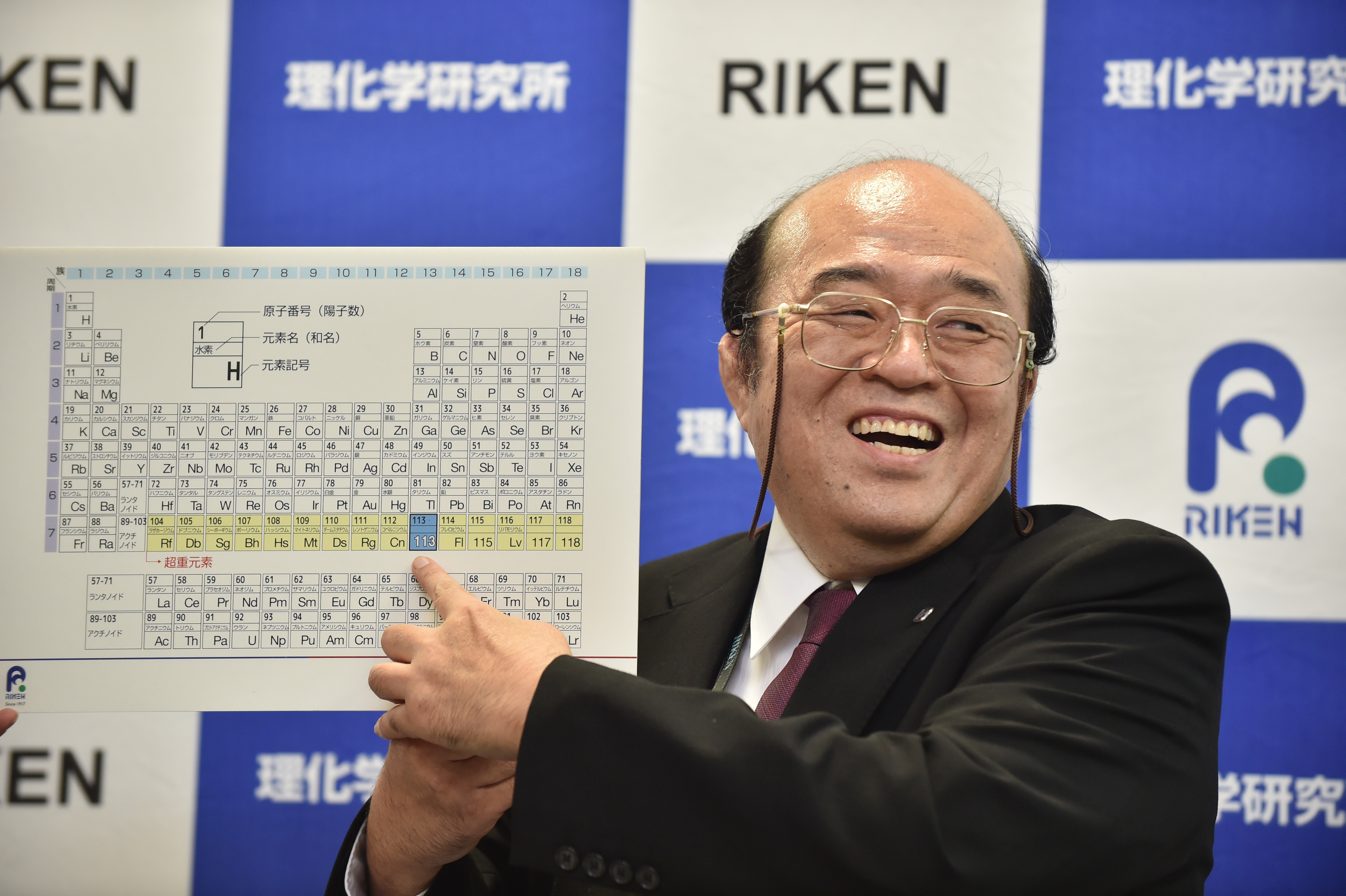 Kosuke Morita, the leader of the Riken team, smiles as he points to a board displaying the new atomic element 113 during a press conference in Wako, Saitama prefecture on December 31, 2015. A Japanese research team has received naming rights for new atomic element 113, the first on the periodic chart to be named by Asian scientists, the team's institute said December 31. Japan's Riken Institute said a team led by Kosuke Morita was awarded the rights from global scientific bodies -- the International Union of Pure and Applied Chemistry (IUPAC) and the International Union of Pure and Applied Physics (IUPAP) -- after successfully creating the new synthetic element three times from 2004 to 2012. AFP PHOTO / KAZUHIRO NOGI / AFP PHOTO / KAZUHIRO NOGI