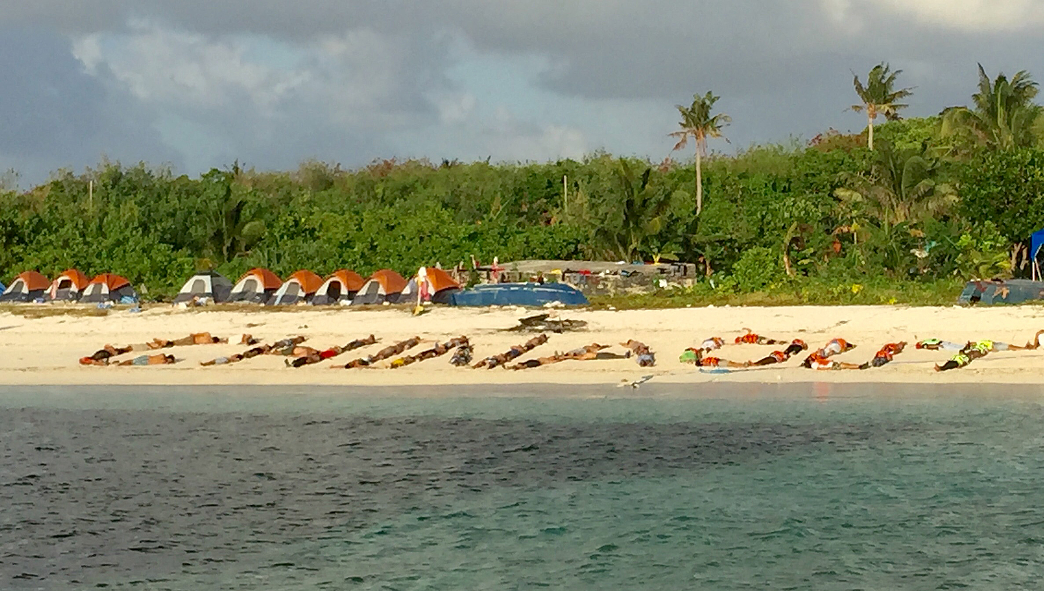 This photo taken on December 31, 2015, shows Filipino children forming a sign 'China Out' during a protest on a beach at Pag-asa island, a remote Philippine-held island in the South China Sea. in the South China Sea claimed by the Philippines. Nearly 50 young Filipinos returned on January 3, 2016 from a remote Philippine-held island in the South China Sea where they had staged a week-long protest against Beijing's claims in the disputed waterway. The group arrived at Pag-asa island on December 26 as part of an effort to stir up popular opposition to China's claim to most of the contested sea, including Pag-asa, also known as Thitu. AFP PHOTO / AFP PHOTO / AFP