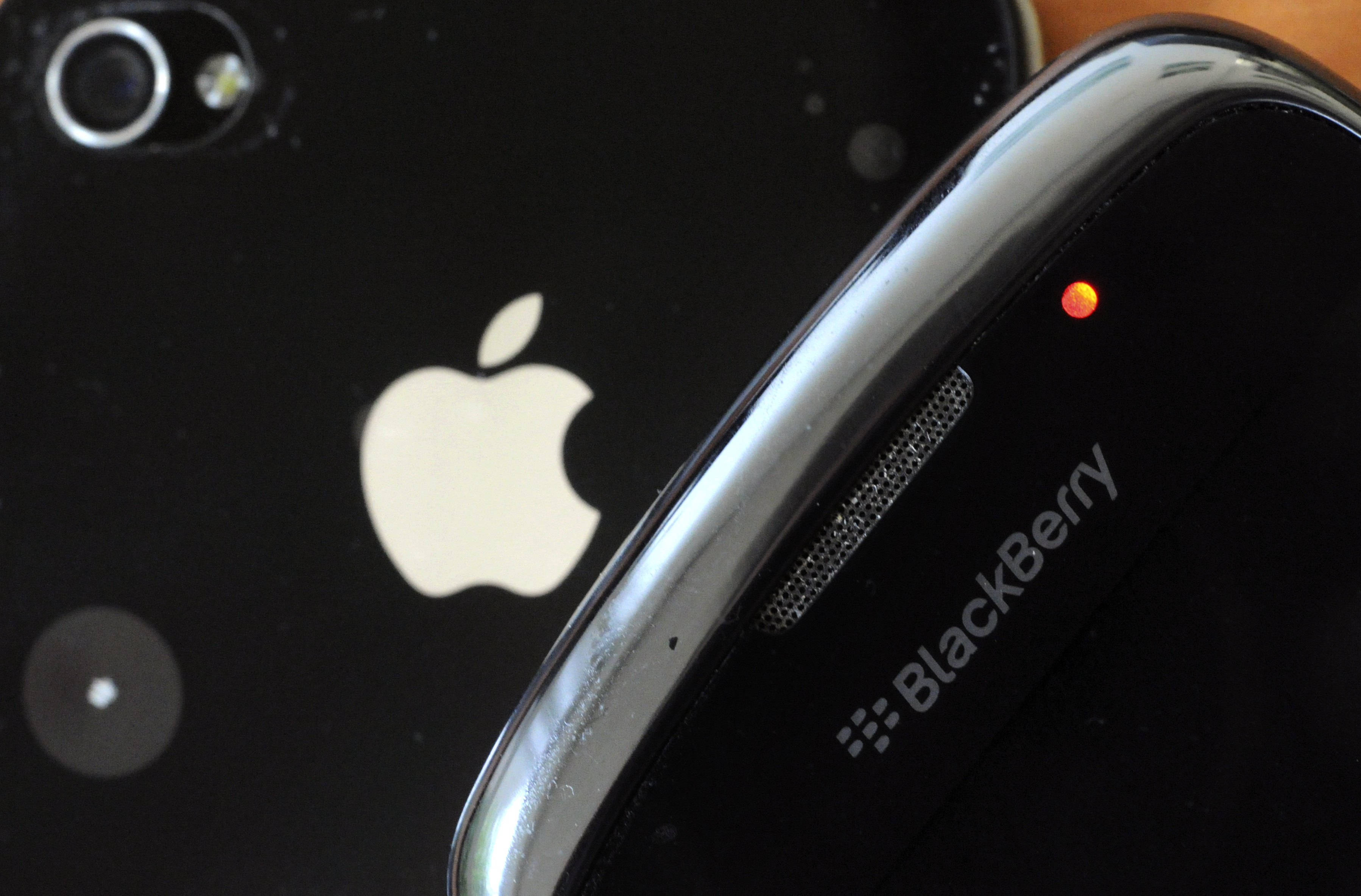 A picture taken on October 12, 2011 in the French western city of Rennes shows a Blackberry mobile phone and an Apple Iphone 4. AFP PHOTO / DAMIEN MEYER / AFP PHOTO / DAMIEN MEYER