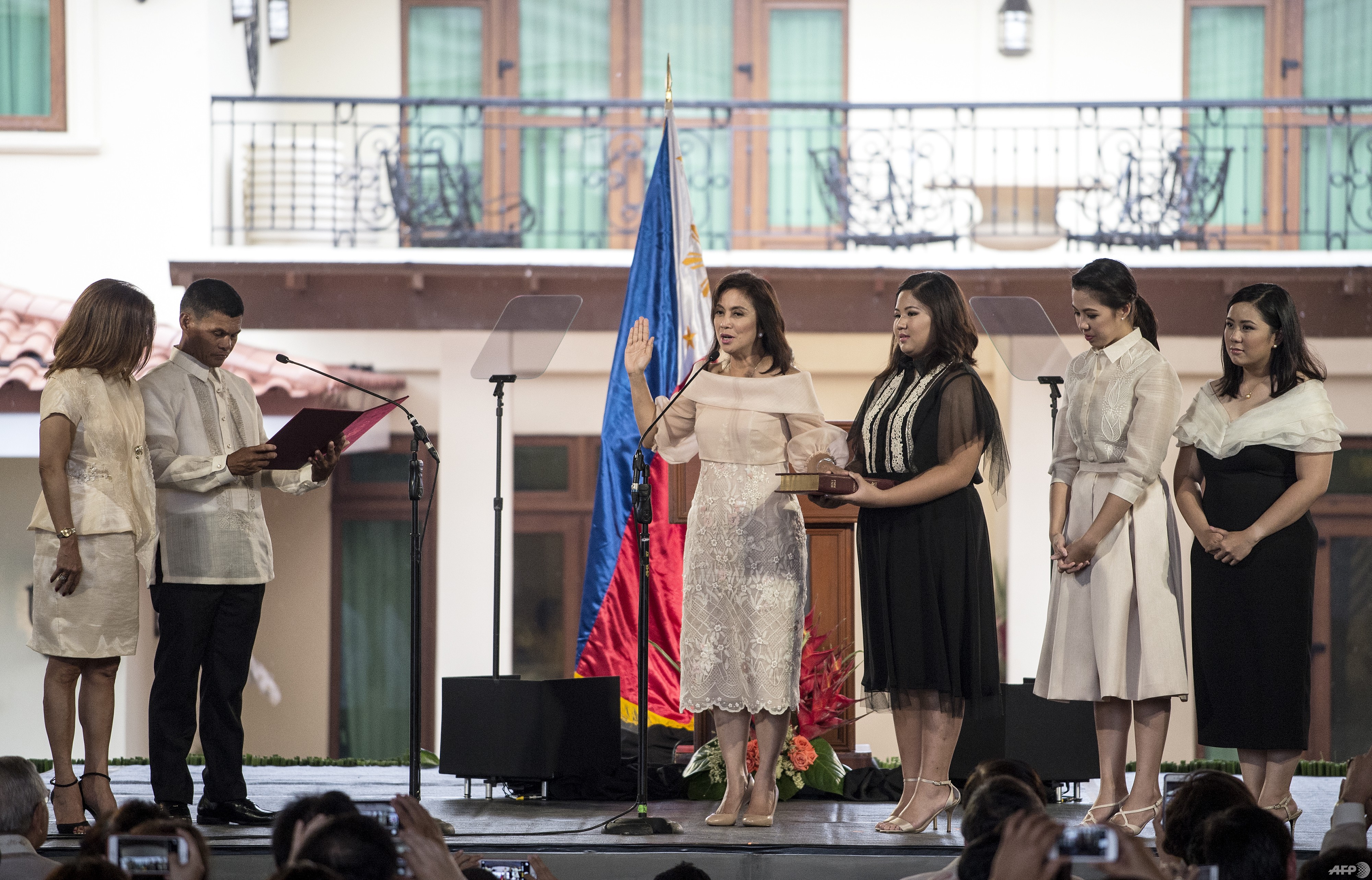 Philippines Vice President Leni Robredo (L) takes an oath administered by Barangay Captain Ronaldo Coner (2nd L) during her inauguration ceremonies with her daughters Jillian Therese (2nd L), Janine Patricia (2nd R) and Jessica Marie (R)at the Quezon City Recepotion House in Manila on June 30, 2016. / AFP PHOTO / NOEL CELIS