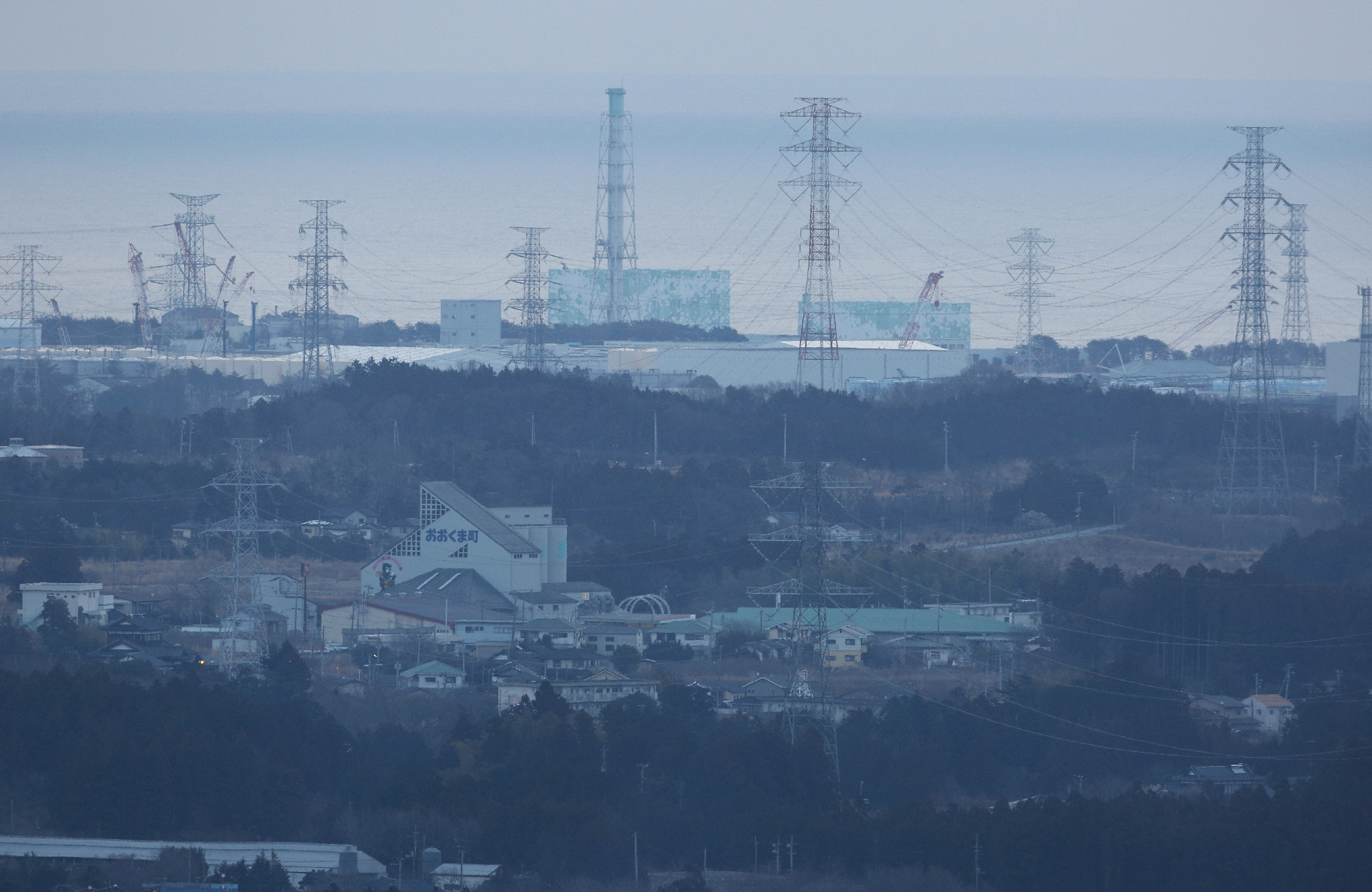 A general view shows the troubled Fukushima Daiichi nuclear power plant (rear) seen from Tomioka town in Fukushima prefecture on March 11, 2016, as people gather to remember the victims of the massive earthquake and tsunami disaster which hit northeastern Japan in 2011. Japan is marking on March 11 the fifth anniversary of the 2011 quake and tsunami that claimed some 18,500 lives, flattened coastal communities and set off the worst atomic crisis in a generation. / AFP PHOTO / JIJI PRESS / JIJI PRESS / Japan OUT