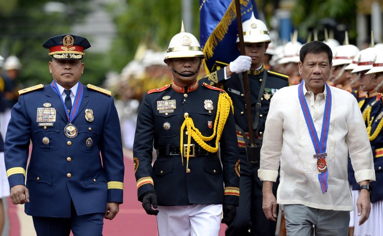Philippine President Rodrigo Duterte (R) walks beside Philippine National Police (PNP) chief Ronald Bato Dela Rosa (L) during Dela Roasa's Assumption of Command Ceremony at the Camp Crame in Manila on July 1, 2016. Authoritarian firebrand Rodrigo Duterte was sworn in as the Philippines' president on June 30, after promising a ruthless and deeply controversial war on crime would be the main focus of his six-year term. / AFP PHOTO / NOEL CELIS