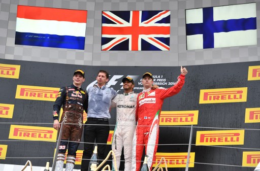 Mercedes AMG Petronas F1 Team's British driver Lewis Hamilton (2nd R) celebrates victory on the podium ahead of Infiniti Red Bull racing's Belgian-Dutch driver Max Verstappen (L) and Ferrari's Finnish driver Kimi Raikkonen (R) with Chief strategist AMG Mercedes Team James Vowles (2nd L) after the Formula One Grand Prix of Austria at the Red Bull Ring in Spielberg, Austria on July 3, 2016.  Mercedes AMG Petronas F1 Team's British driver Lewis Hamilton won the race ahead of Infiniti Red Bull racing's Belgian-Dutch driver Max Verstappen (2nd) and Ferrari's Finnish driver Kimi Raikkonen (3rd). / AFP PHOTO / ANDREJ ISAKOVIC