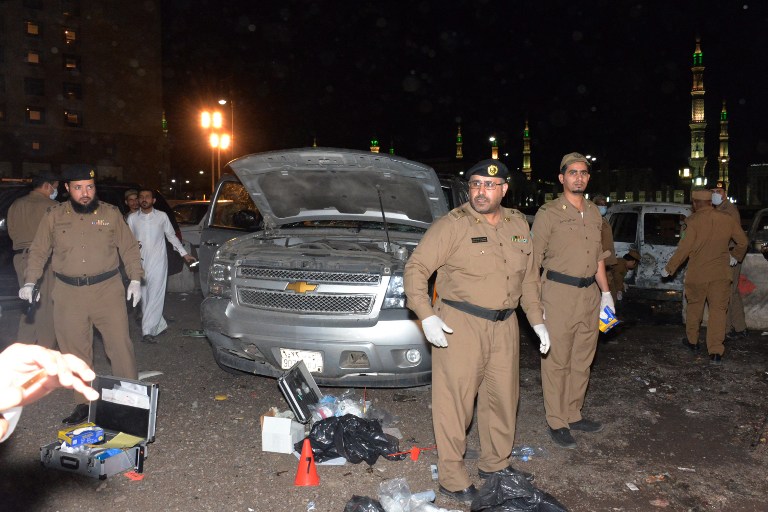Saudi security personel gather at the site of the suicide attack near the security headquarters of the Prophet's Mosque in Medina City on July 4, 2016. Four Saudi security personnel were killed and five others were wounded in a suicide bombing today outside one of Islam's holiest sites, the Prophet's Mosque in Medina, the interior ministry said. / AFP PHOTO / STR