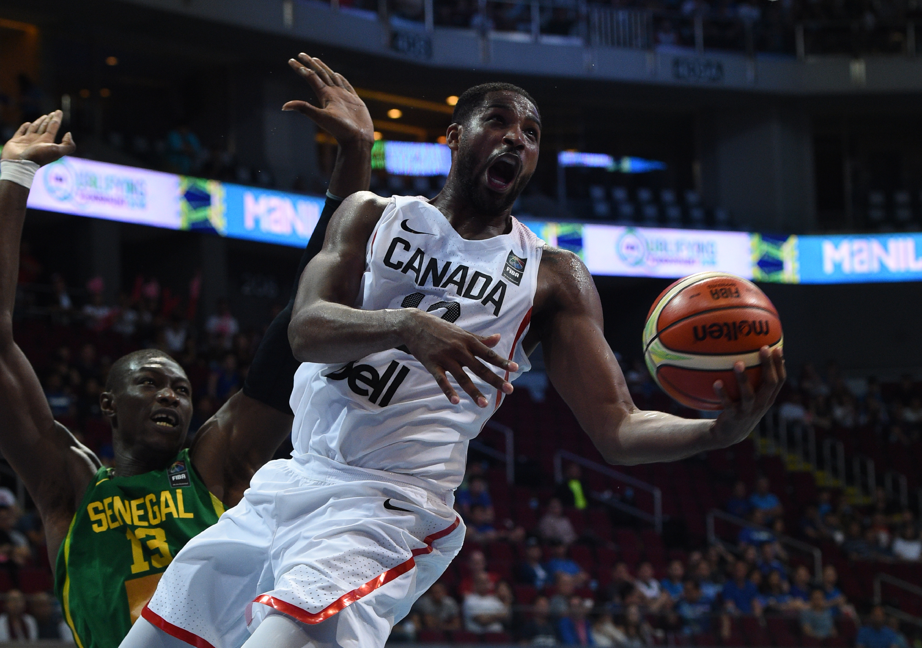Tristan Thompson of Canada (R) goes up for a shot as Hamady Indiaye of Senegal defends during their 2016 FIBA Olympic men's qualifying basketball tournament in Manila on July 6, 2016. / AFP PHOTO / TED ALJIBE