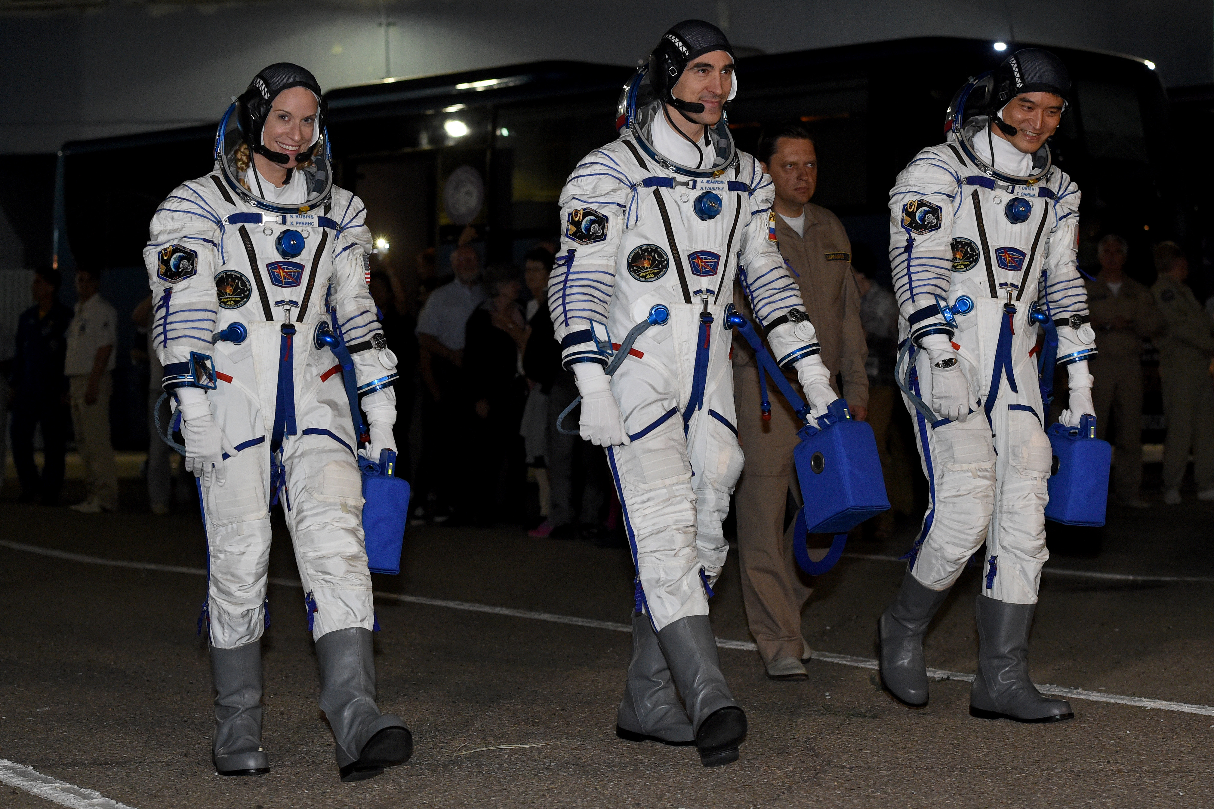 (L-R) US astronaut from NASA Kate Rubins, cosmonaut Anatoly Ivanishin of the Russian space agency Roscosmos and astronaut Takuya Onishi of the Japan Aerospace Exploration Agency walk after their space suits were tested at the Russian-leased Baikonur cosmodrome in Kazakhstan, prior to blasting off to the International Space Station (ISS) early on July 7, 2016 local time. They will launch at 9:36 p.m. (7:36 a.m. Baikonur time, July 7, 2016) from the Baikonur Cosmodrome in Kazakhstan. All three will spend approximately four months on the orbital complex, returning to Earth in October. / AFP PHOTO / VASILY MAXIMOV
