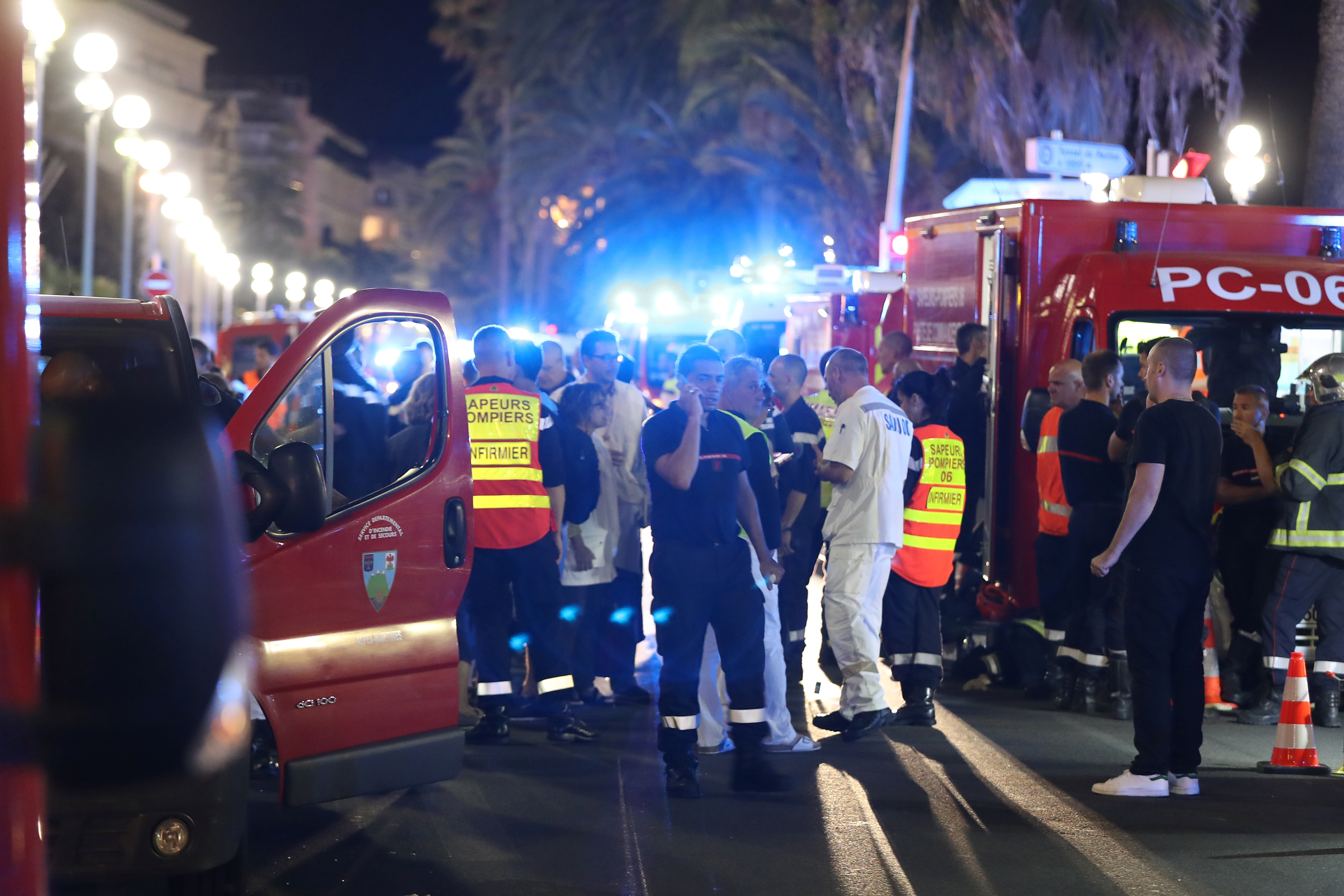 Police officers, firefighters and rescue workers are seen at the site of an attack on the Promenade des Anglais on July 15, 2016, after a truck drove into a crowd watching a fireworks display in the French Riviera town of Nice. A truck ploughed into a crowd in the French resort of Nice on July 14, leaving at least 60 dead and scores injured in an "attack" after a Bastille Day fireworks display, prosecutors said on July 15.  / AFP PHOTO / Valery HACHE