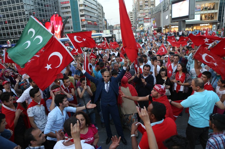 People gather at Kizilay Square in Ankara on July 18, 2016 to protest against Parallel State/Gulenist Terrorist Organization's failed military coup attempt.  Turkey launched fresh raids and sacked almost 9,000 officials today in a relentless crackdown against suspects behind an attempted coup that left over 300 people dead, as Western allies warned against reinstating the death penalty. / AFP PHOTO / ADEM ALTAN