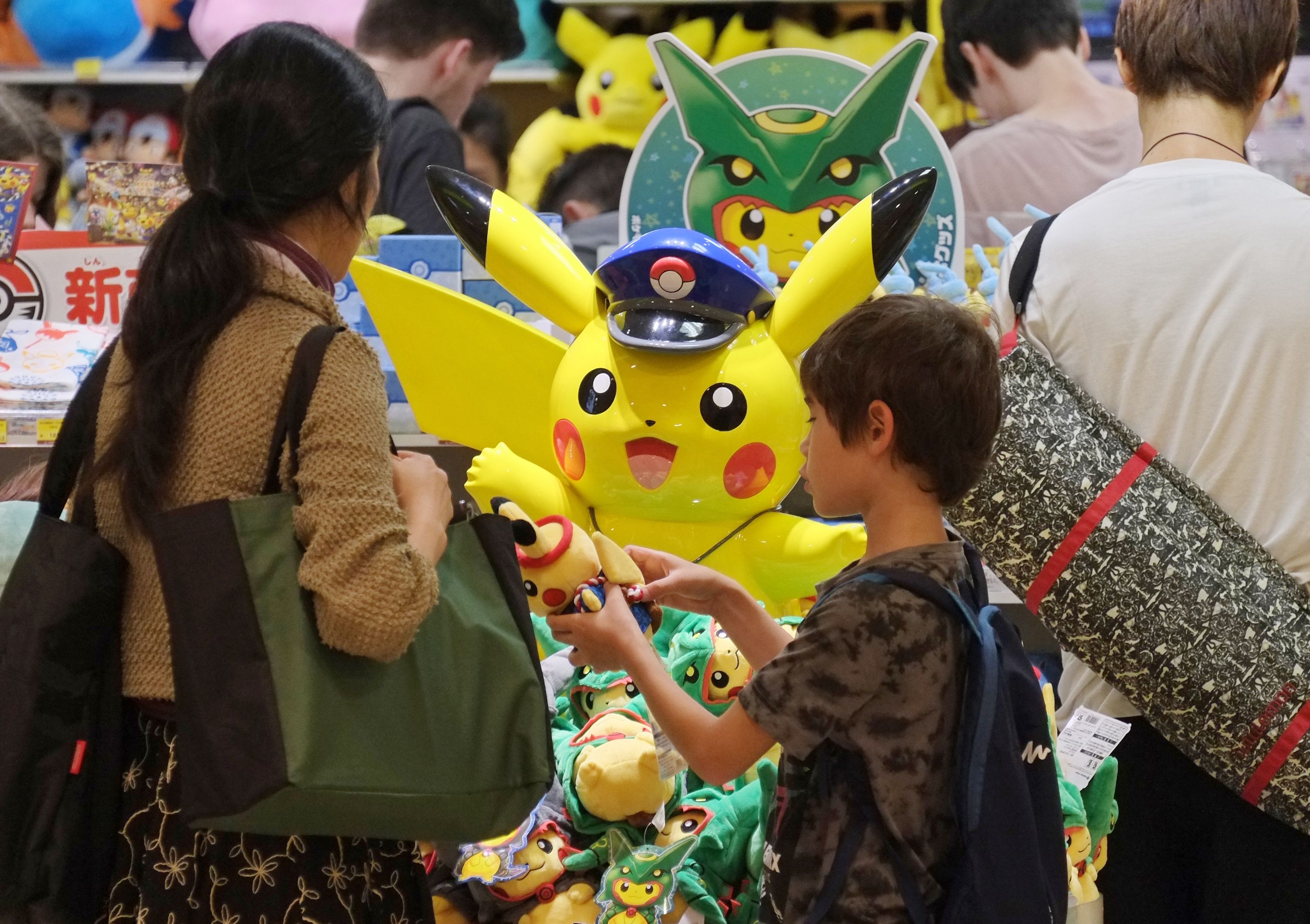 (FILES) This July 13, 2016 file picture shows customers visiting a shop selling Pokemon goods in Tokyo. Nintendo shot past Sony in market value on July 19, 2016 after the videogame giant's stock more than doubled since the release of the wildly popular Pokemon Go game. / AFP PHOTO / KAZUHIRO NOGI / - Japan OUT