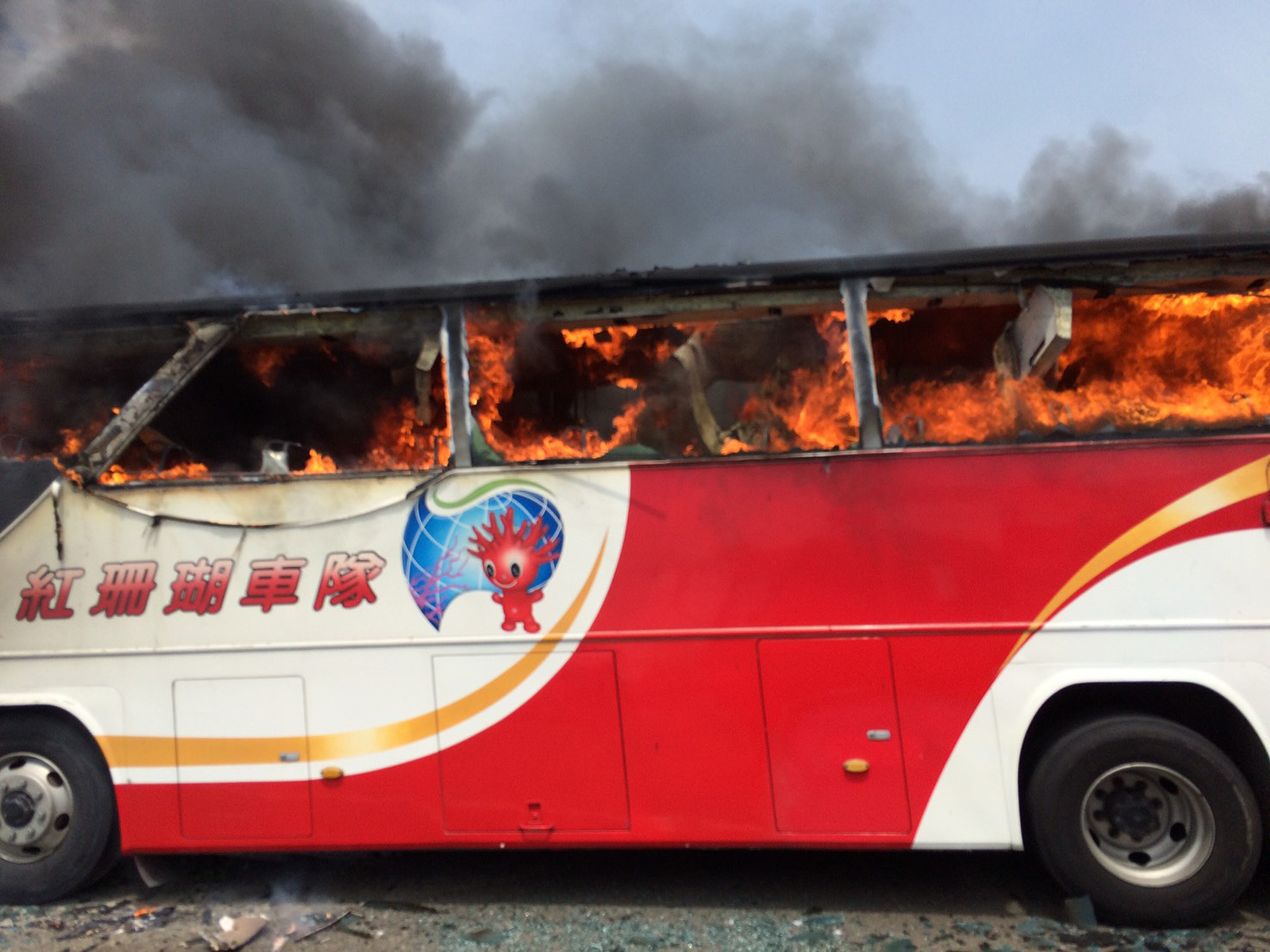 This handout photo taken and released by the Taoyuan City Fire Department on July 19, 2016 shows a bus carrying tourists from mainland China on fire after it crashed along an expressway on its way to the airport in Taiwan's city of Taoyuan on July 19, 2016. The Taiwan tour bus carrying visitors from mainland China crashed and caught fire on July 19 near the capital Taipei, killing 26 on board.  / AFP PHOTO / TAOYUAN CITY FIRE DEPARTMENT / TAOYUAN CITY FIRE DEPARTMENT / -----EDITORS NOTE --- RESTRICTED TO EDITORIAL USE - MANDATORY CREDIT "AFP PHOTO / TAOYUAN CITY FIRE DEPARTMENT" - NO MARKETING - NO ADVERTISING CAMPAIGNS - DISTRIBUTED AS A SERVICE TO CLIENTS - NO ARCHIVES