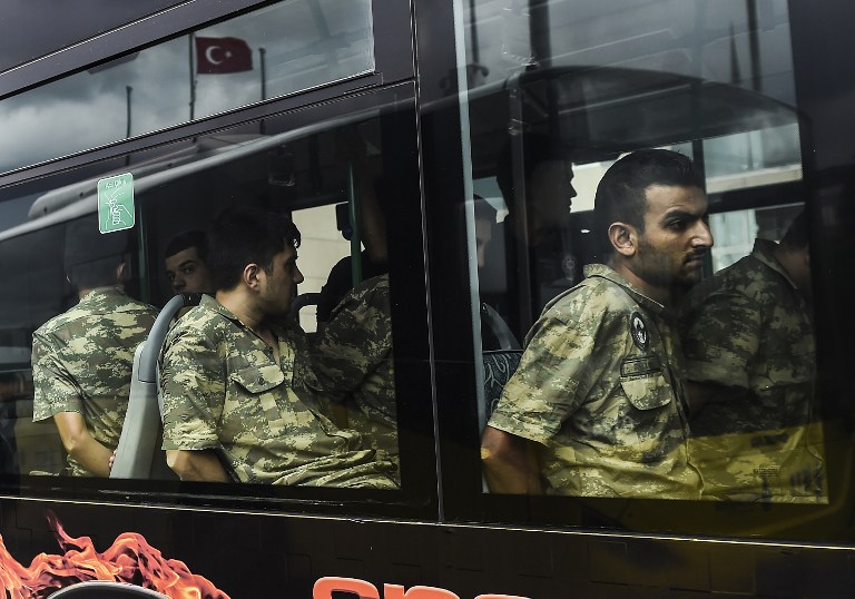Detained Turkish soldiers who allegedly took part in a military coup arrive in a bus at the courthouse in Istanbul on July 20, 2016, following the military coup attempt of July 15. Turkish President Recep Tayyip Erdogan was today to chair a crunch security meeting in Ankara for the first time since the failed coup, with tens of thousands either detained or sacked from their jobs in a widening purge. / AFP PHOTO / BULENT KILIC