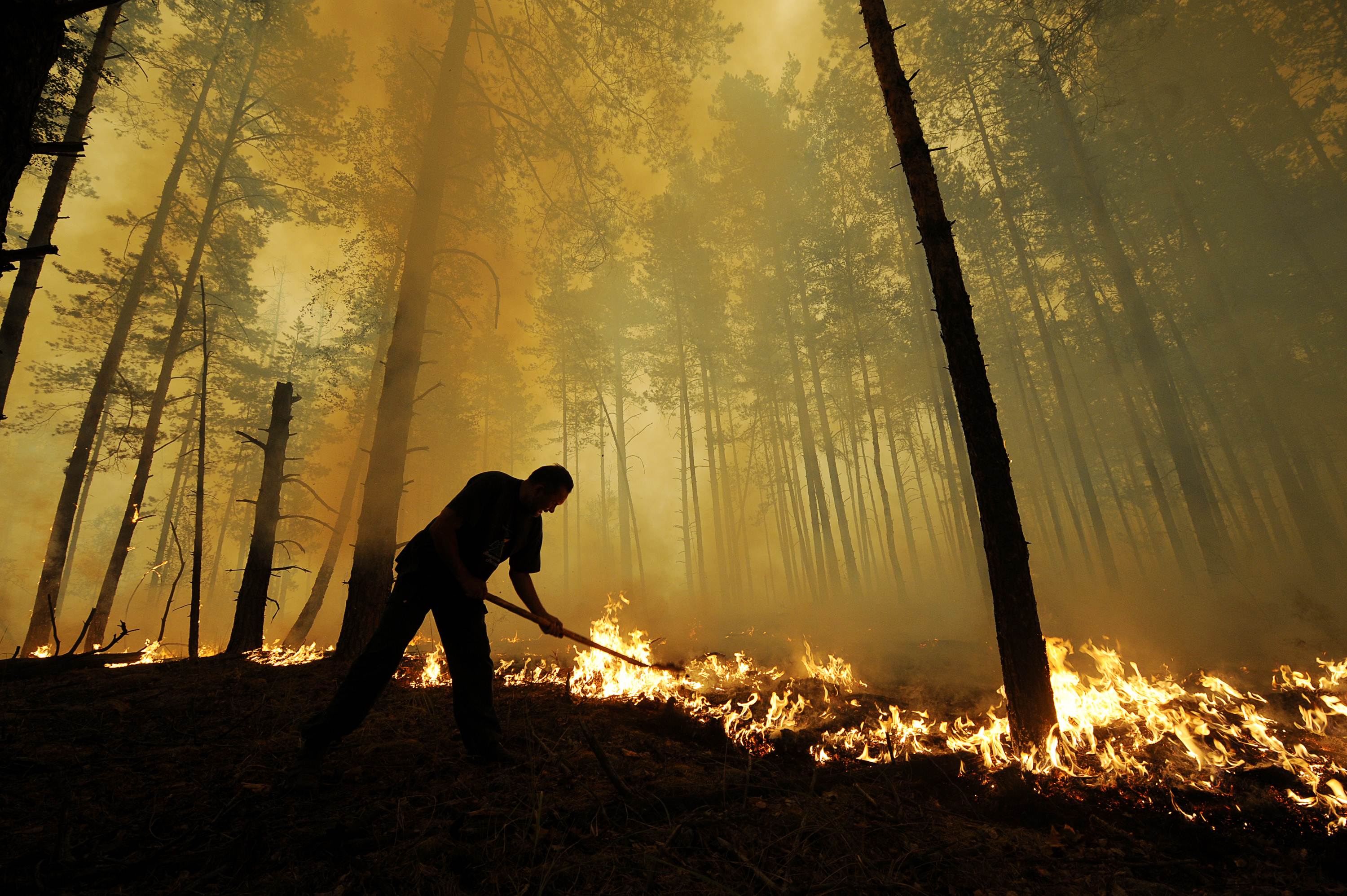 (FILES) This file photo taken on August 05, 2010 shows a Russian trying to stop fire near the village of Golovanovo, Ryazan region. Russia's practice of leaving massive wildfires to burn out of control in sprawling stretches of Siberia puts at risk a key global resource for absorbing climate-warming emissions: its trees. / AFP PHOTO / Natalia KOLESNIKOVA