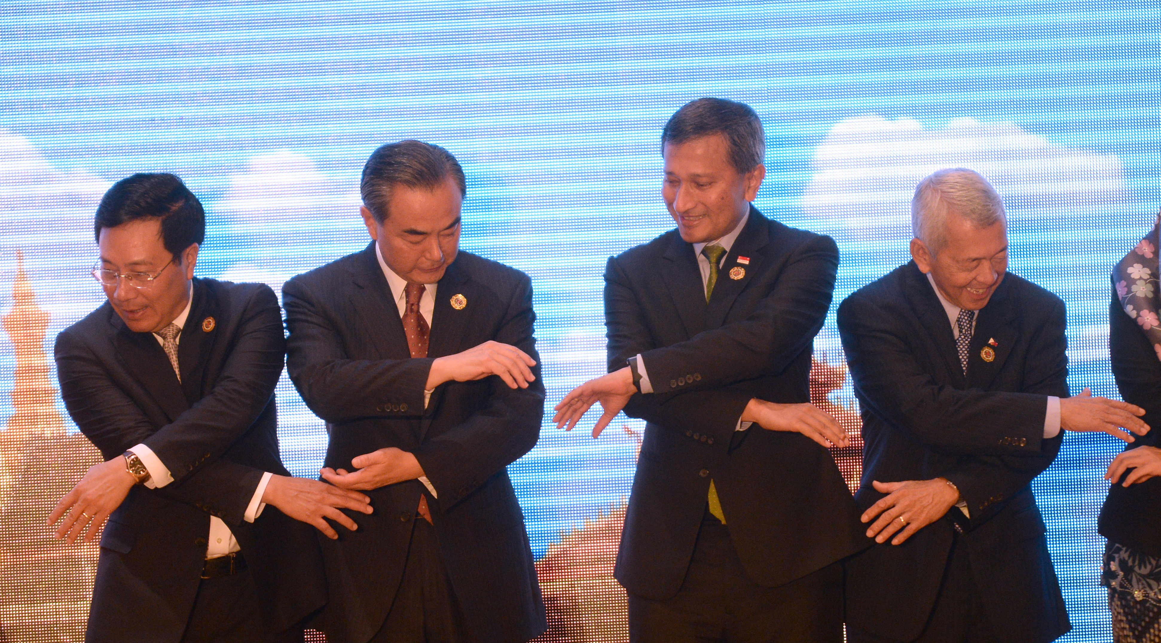 China's Foreign Minister Wang Yi (2nd L), Singapore's Foreign Minister Vivian Balakrishnan (2nd R), Vietnam's Foreign Minister Pham Binh Minh (L) and Philippines' Foreign Secretary Perfecto Yasay (R) join hands as they pose for a group photo during the ASEAN-China meeting on the sidelines of the Association of Southeast Asian Nations (ASEAN) annual ministerial meeting and the Regional Security Forum in Vientiane on July 25, 2016. Southeast Asian nations were deadlocked on July 24 about how to confront China's territorial claims in the South China Sea as pressure from Beijing again drove a wedge between countries on the region's toughest security challenge. / AFP PHOTO / HOANG DINH NAM