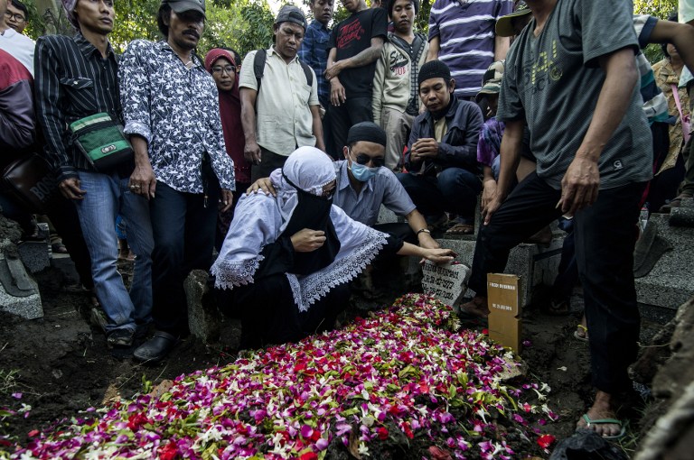 Family members mourn at the grave of Indonesia man Freddy Budiman in Surabaya, East Java, on July 29, 2016 after his execution at Nusa Kambangan island. Indonesia on July 29 executed four drug convicts on July 29 but 10 others due to face the firing squad were given an apparent reprieve in a confused process one lawyer condemned as a "complete mess". / AFP PHOTO / JUNI KRISWANTO