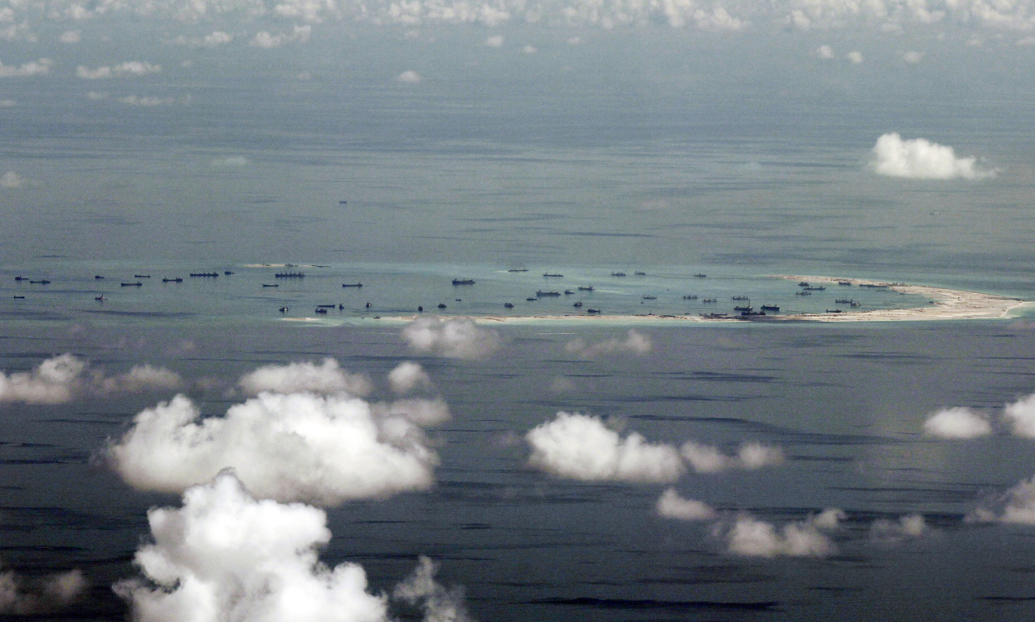 This aerial photograph taken from a military aircraft shows alleged on-going reclamation by China on Mischief Reef in the Spratly group of islands in the South China Sea, west of Palawan, on May 11, 2015. The Spratlys are considered a potential Asian flashpoint, and claimant nations including the Philippines have expressed alarm as China has embarked on massive reclamation activity. AFP PHOTO / POOL / RITCHIE B. TONGO / AFP PHOTO / POOL / RITCHIE B. TONGO