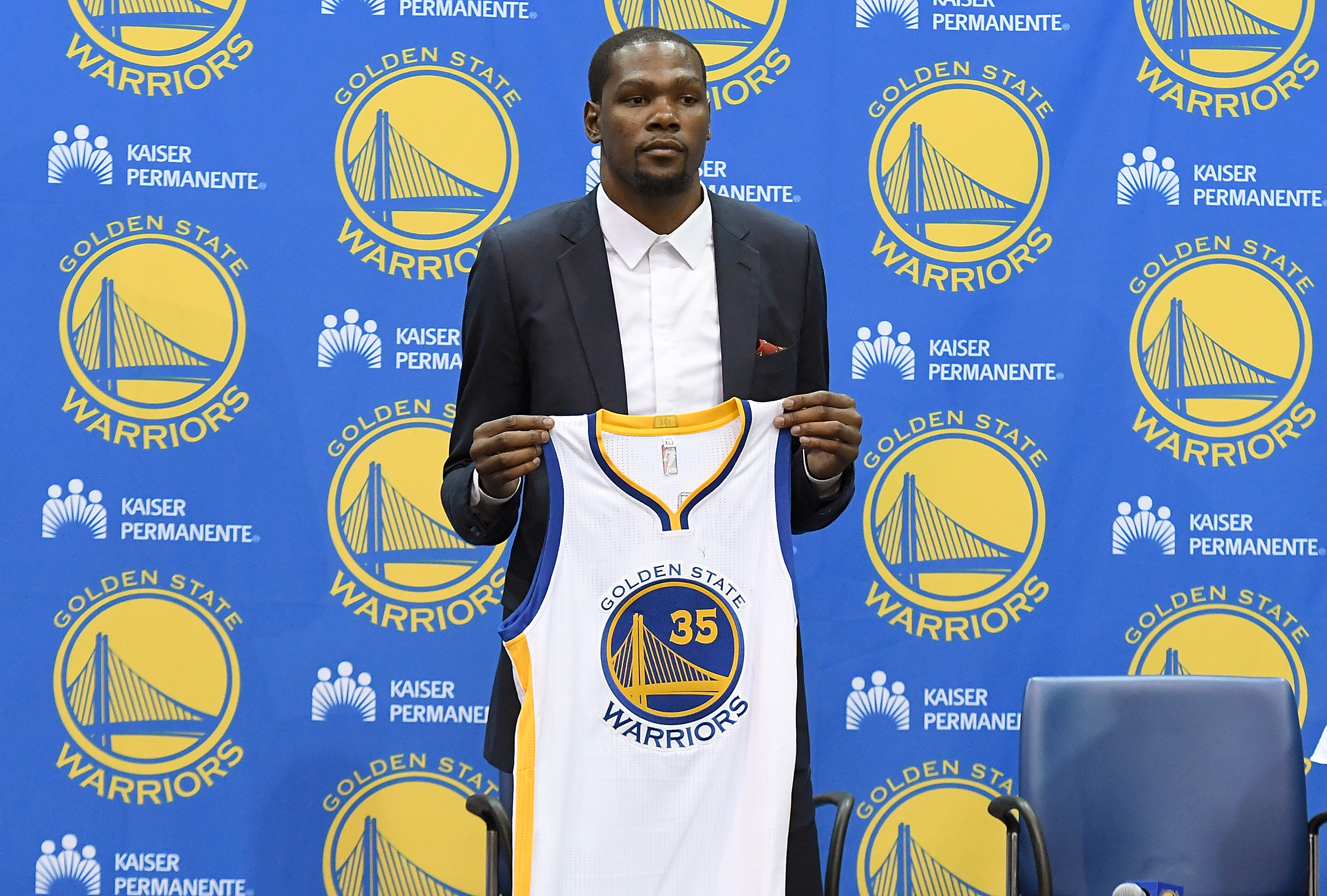 OAKLAND, CA - JULY 07: Kevin Durant #35 of the Golden State Warriors poses with his new jersey during the press conference where he was introduced as a member of the Golden State Warriors after they signed him as a free agent on July 7, 2016 in Oakland, California.   Thearon W. Henderson/Getty Images/AFP