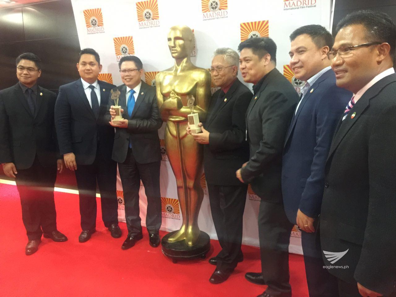 Some of the Iglesia Ni Cristo ministers based in Europe, pose for a photo, carrying the two trophies won by "Walang Take Two" during the awards night of of the Madrid International Film Festival on Saturday, July 9, 2016.