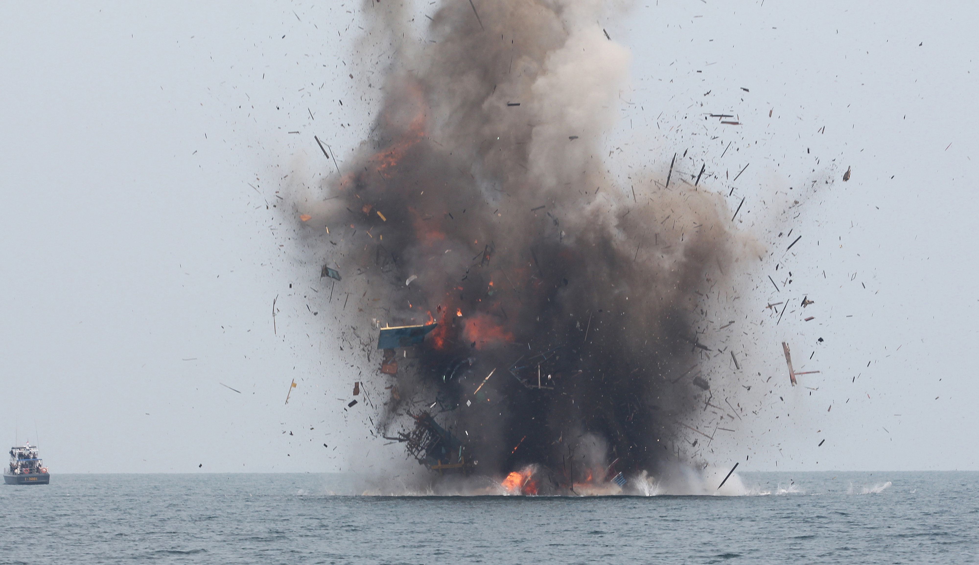 (FILES) This file photo taken on April 5, 2016 shows an illegal fishing boat being blown up with explosives by Indonesian authorities in Kuala Langsa, Aceh province. Indonesia will sink up to 71 impounded foreign boats this month on its Independence Day, a minister said on August 1, 2016, ramping up a campaign to deter illegal fishing in its vast waters. / AFP PHOTO / JANUAR