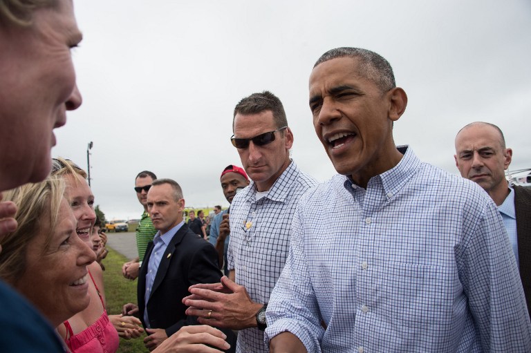 US President Barack Obama greets wellwishers upon arrival at Martha's Vineyard on August 6, 2016 after arriving with family for a two-week holiday. Obama on Saturday urged Americans to set aside political differences and unite to support the US athletes at the Summer Olympics under way in Rio de Janeiro./ AFP PHOTO / NICHOLAS KAMM