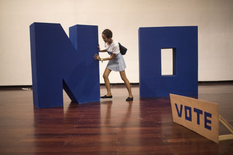 A Thai coordinator for New Democracy removes a 'No' installation after the 'Yes' victory in the Constitutional Referendum at Thammasat University on August 7, 2016.  Thailand voted August 7 to approve a junta-scripted constitution, preliminary results showed, in a boost to the army's political aspirations and a body blow to the country's stuttering pro-democracy movement. The military says its new constitution will curb endemic political corruption, bring stability after years of unrest and pave the way for a general election next year.  / AFP PHOTO / BORJA SANCHEZ-TRILLO