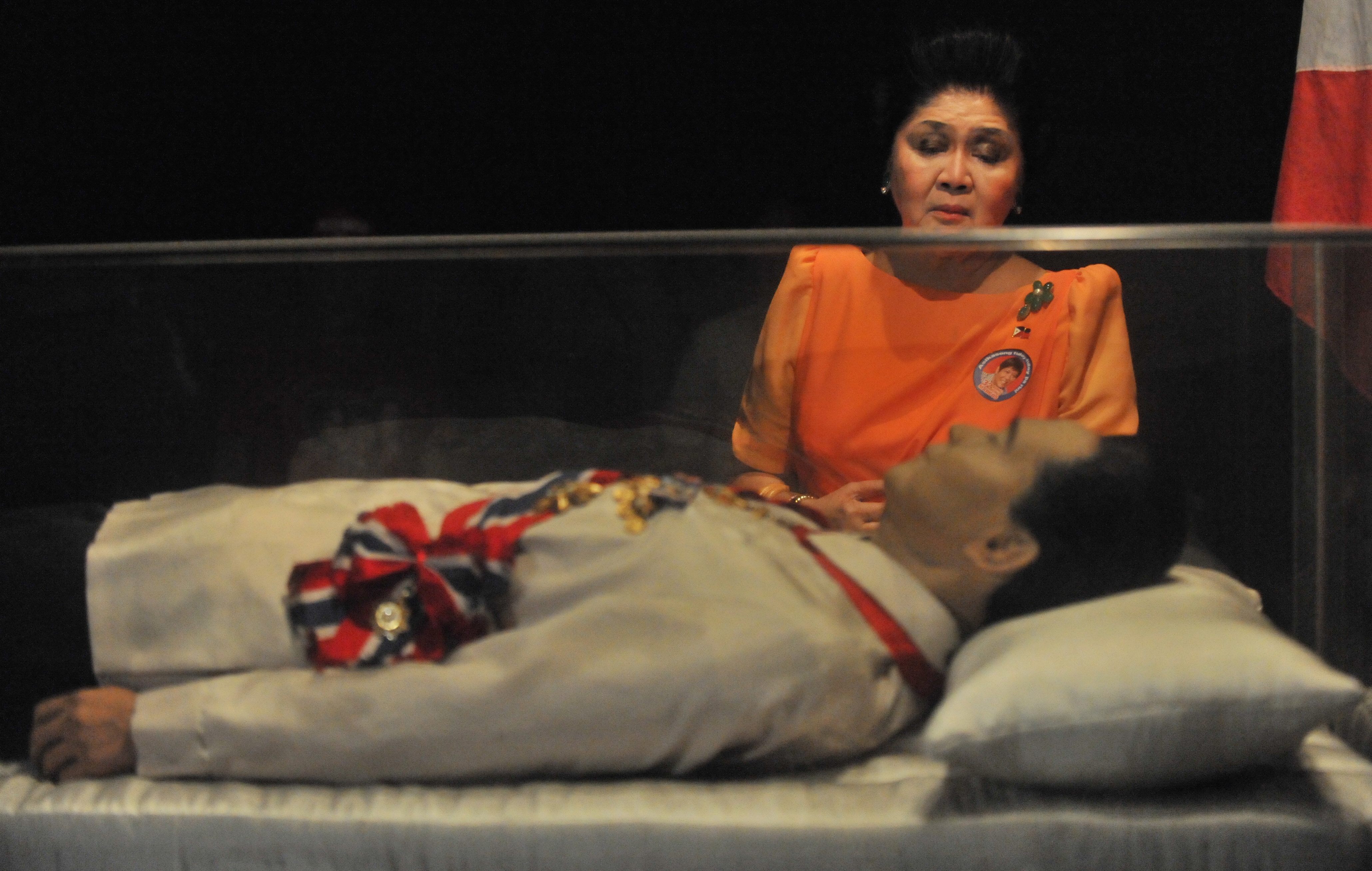 (FILES) This file photo taken on March 26, 2010 shows former Philippine first lady Imelda Marcos looking at the embalmed body of her husband former leader Ferdinand Marcos prior to an election campaign trip in the town of Batac, Ilocos norte province, north of Manila. Philippine activists and a historical body on August 8, 2016 criticised President Rodrigo Duterte's plan to give late dictator Ferdinand Marcos a hero's burial, saying the ex-leader lied about his military record. / AFP PHOTO / TED ALJIBE