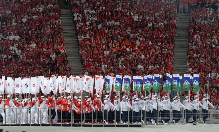 Contingents march inside the national stadium during National Day celebrations in Singapore on August 9, 2016. Singapore celebrated its 51st anniversary as a republic on August 9 under tight air, sea and land security after the discovery of an Indonesian extremist plot to attack the city-state. / AFP PHOTO / ROSLAN RAHMAN