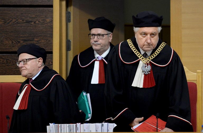 Poland's Constitutional Court Chief Justice Andrzej Rzeplinski (R) surrounded by other judges arrives in the courtroom on August 11, 2016 in Warsaw. Poland's Constitutional Court on struck down yet another set of government reforms on its operation, deepening a constitutional crisis and hurtling Warsaw toward a collision with the European Union. / AFP PHOTO / JANEK SKARZYNSKI