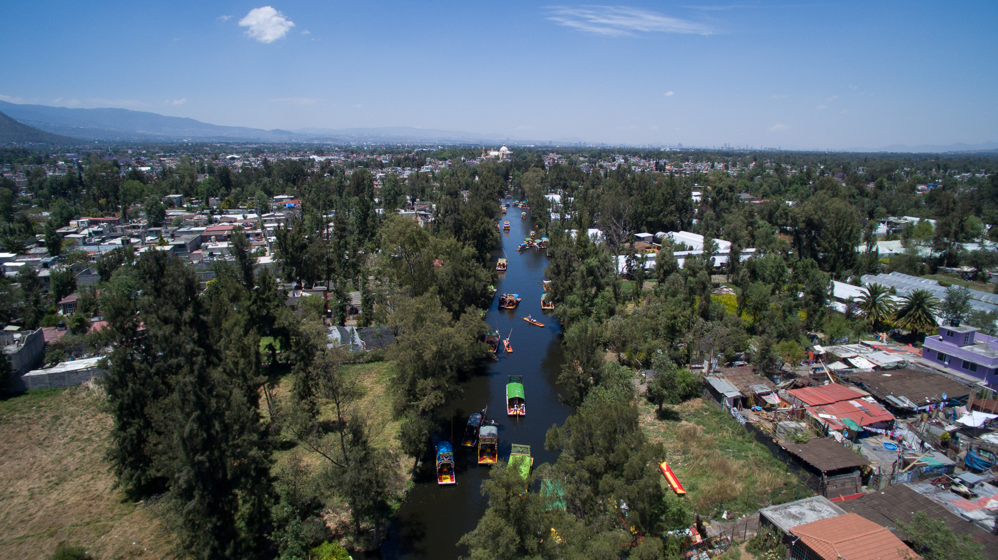 (FILES) This file photo taken with a drone on April 01, 2016 shows an aerial view of "trajineras" -traditional flat-bottomed river boat- at Xochimilco natural reserve in Mexico City.  Xochimilco, a tourist neighborhood of southern Mexico City, is being threatened by the urban development of the megalopolis, which moves forward over its 10,500 protected hectares. / AFP PHOTO / MARIO VAZQUEZ / XGTY - TO GO WITH AFP STORY