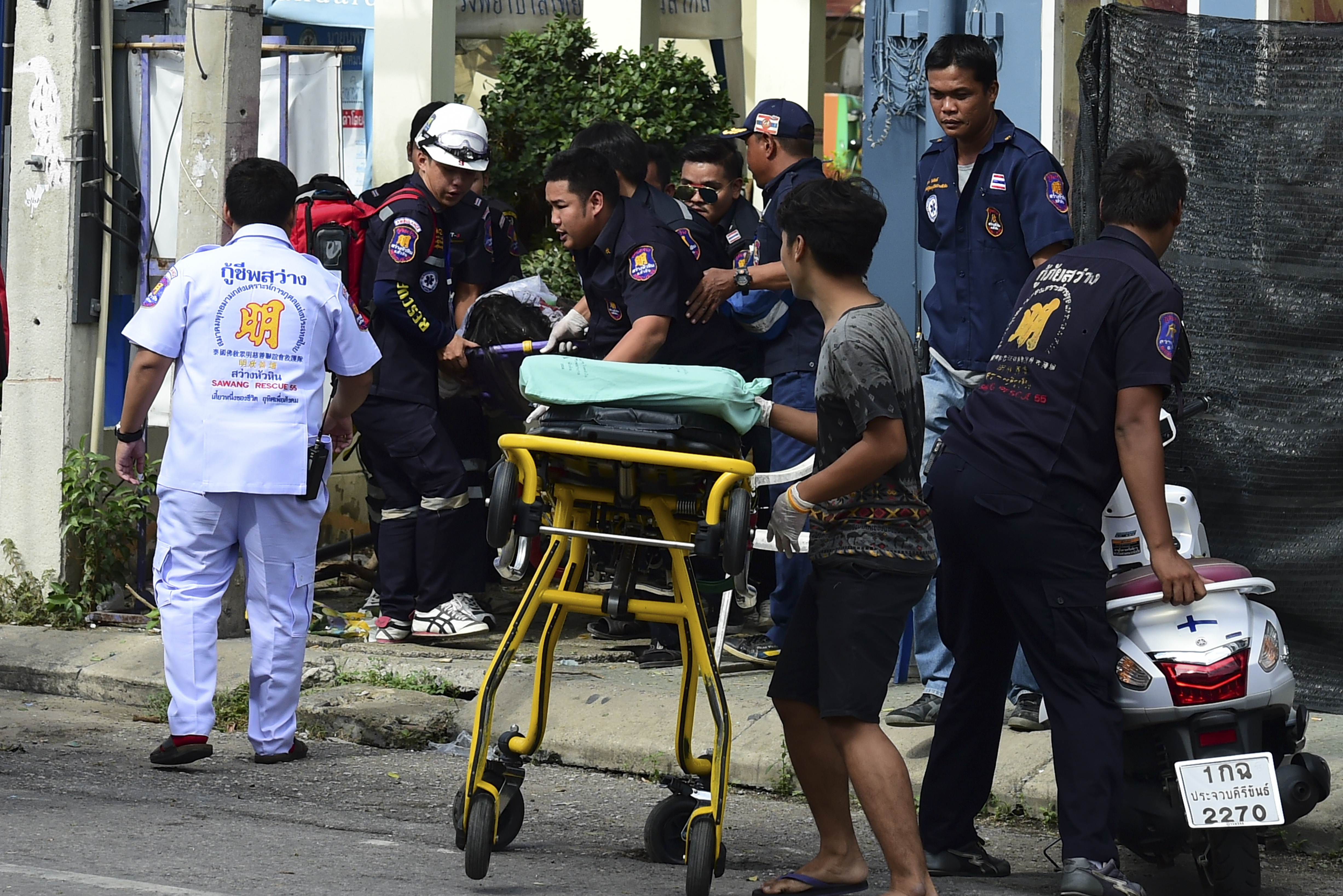 Thai rescue workers attend to an injured victim after a small bomb exploded in Hua Hin on August 12, 2016. At least four people have been killed in eight bomb blasts that have hit across Thailand in the past 24 hours, in the resort town of Hua Hin and southern provinces, authorities said. / AFP PHOTO / MUNIR UZ ZAMAN