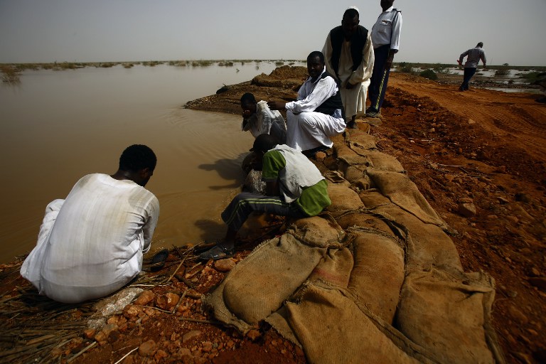 Sudanese drink from a river after heavy flooding on August 15, 2016, in the impoverished eastern state of Kasala bordering Eritrea. Thousands of houses have been destroyed and several villages submerged after flooding triggered by torrential rainfall killed 100 people across Sudan, officials and an AFP photographer said. / AFP PHOTO / ASHRAF SHAZLY