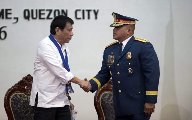 Philippine President Rodrigo Duterte (L) shakes hands with Philippine National Police (PNP) director General Ronal Dela Rosa during the 115th Police Service Anniversary at the Philippine National Police (PNP) headquarters in Manila on August 17, 2016. Philippine President Rodrigo Duterte lashed out at the United Nations for criticising the growing number of killings under his anti-drug campaign. / AFP PHOTO / AFP POOL / NOEL CELIS