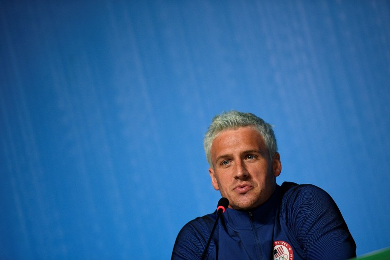 (FILES) This file photo taken on August 03, 2016 shows US swimmer Ryan Lochte holding a press conference in Rio de Janeiro, two days ahead of the opening ceremony of the Rio 2016 Olympic Games. Brazilian police have prevented two more U.S. swimmers from leaving the country after the Rio de Janeiro Olympics over the investigation of a robbery complaint by teammate Ryan Lochte. According to a report on O Globo Web site, swimmers Gunnar Bentz and Jack Conger were arrested and removed from their plane so Brazilian federal police could interview them Wednesday night. The U.S. Olympic Committee later confirmed their detention. / AFP PHOTO / MARTIN BUREAU